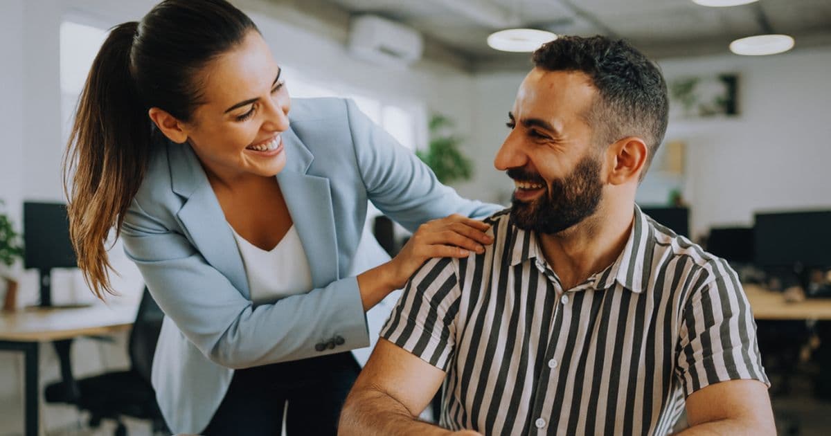 Career services staff supporting job seekers with digital resume tools in a community employment center