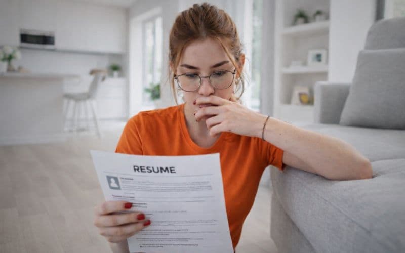 Gen Z job seeker reviewing her resume in a modern home, representing early career planning, resume building, and first job applications.