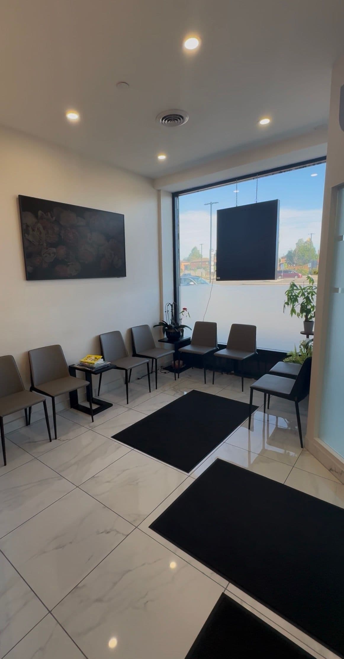 A dental clinic front desk team reviewing patient feedback together on a tablet in a clean, modern reception area