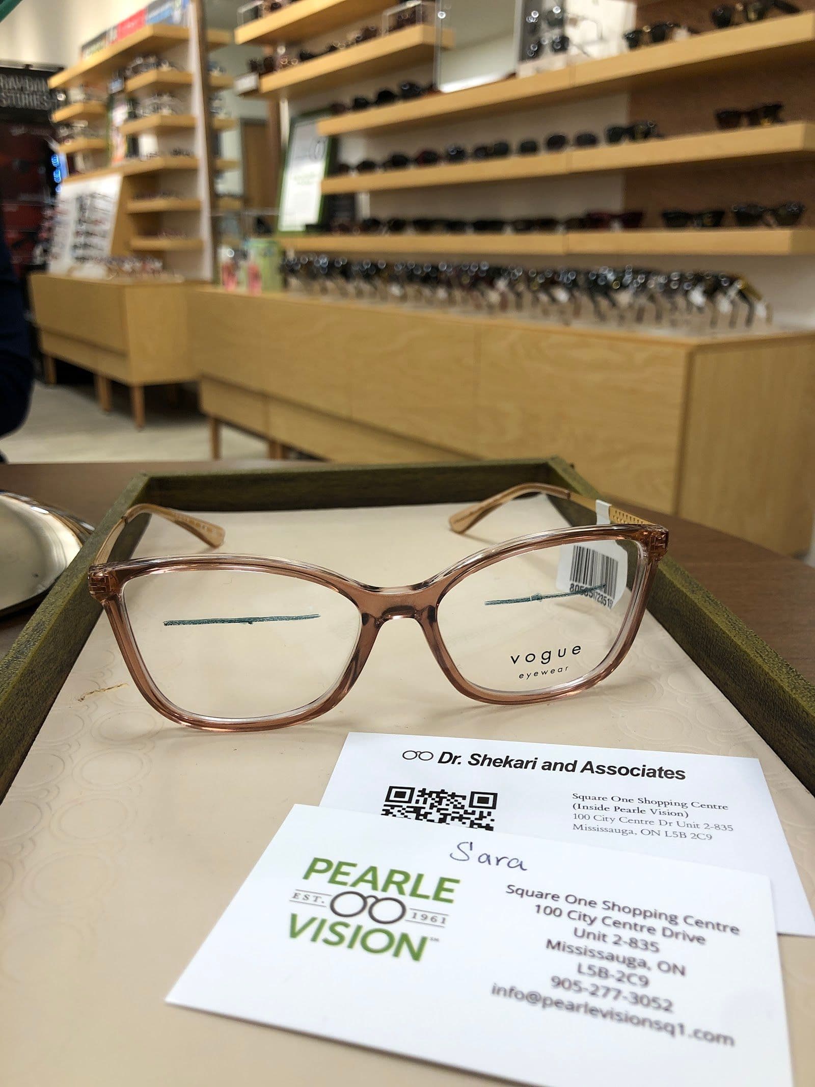Optometry clinic team reviewing patient feedback together at the front desk of an eyewear practice