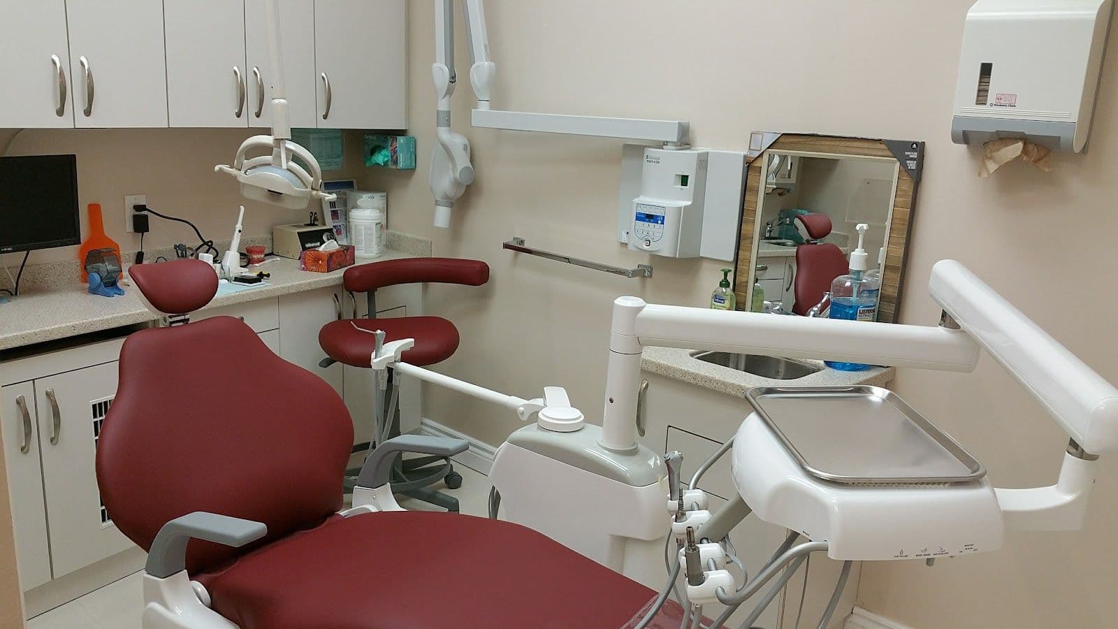 Dental clinic front desk team reviewing patient feedback together on a tablet in a bright, welcoming reception area
