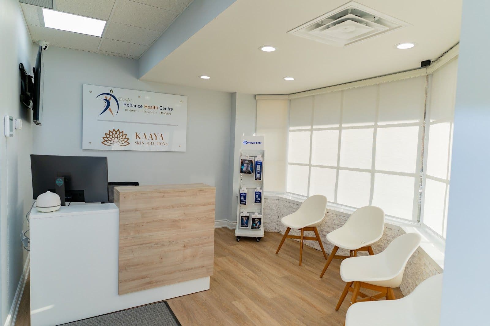Chiropractic clinic front desk team reviewing patient feedback together on a tablet in a clean, welcoming treatment area