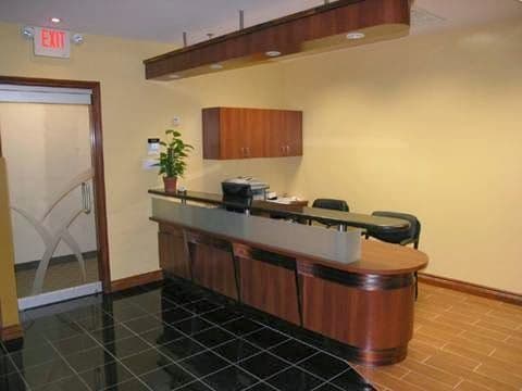 Orthodontic clinic front desk team reviewing patient feedback together on a tablet in a bright reception area