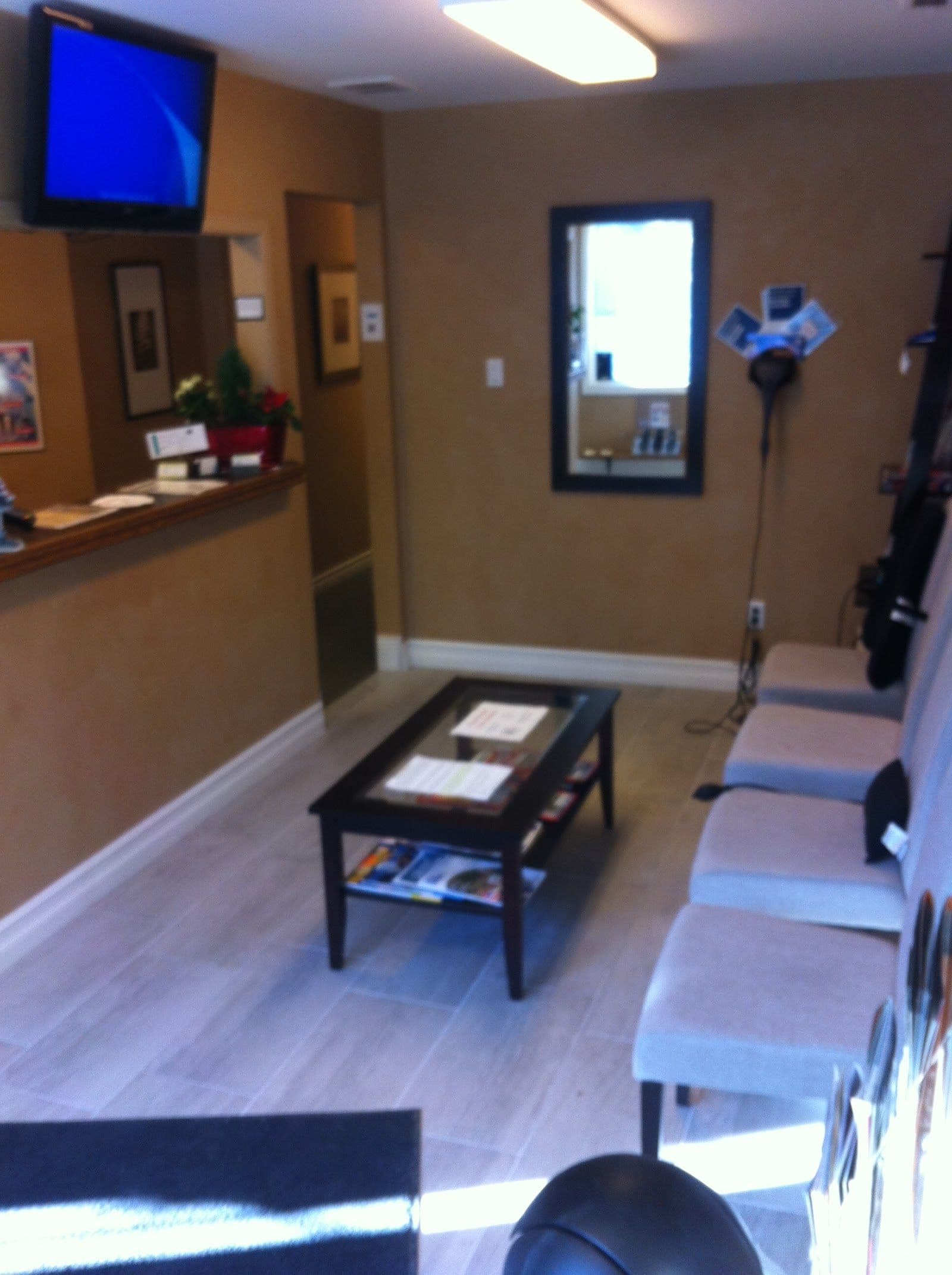 Chiropractic clinic front desk team reviewing patient feedback together on a tablet in the reception area