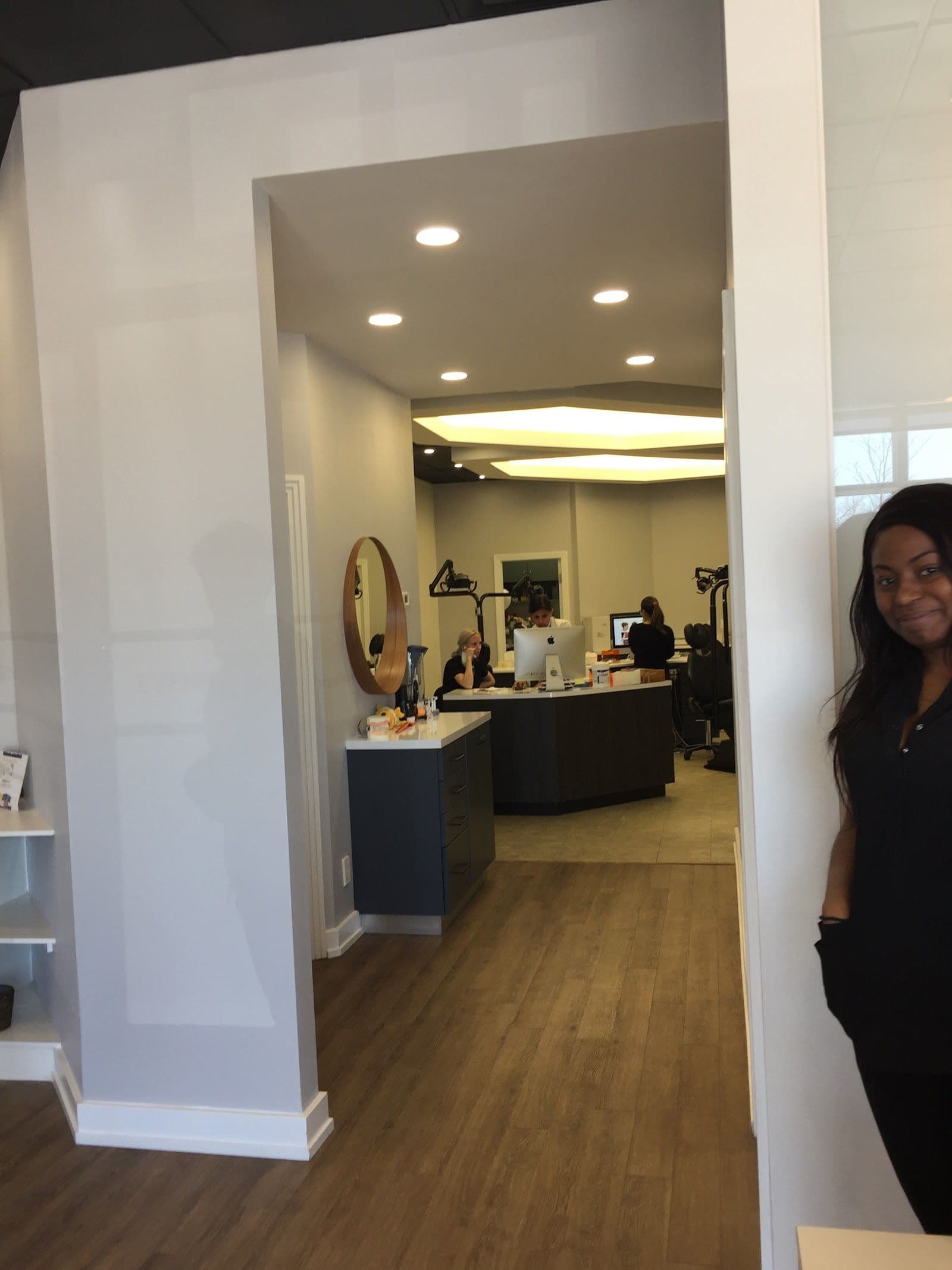 Orthodontic clinic team member reviewing patient feedback and Google reviews on a tablet at the front desk
