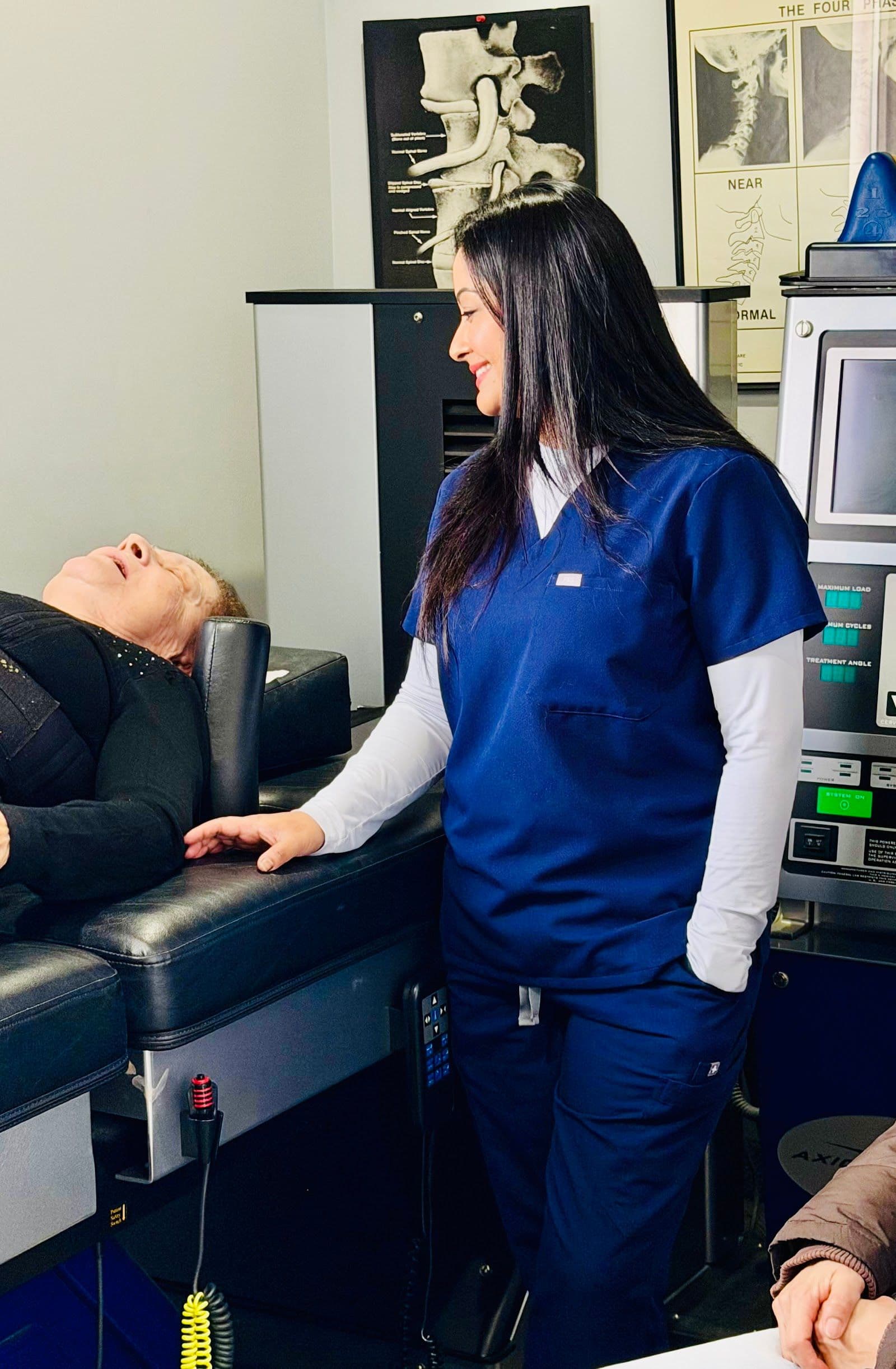 Chiropractic clinic team reviewing patient feedback together at the front desk, with a tablet showing Google reviews and patient themes