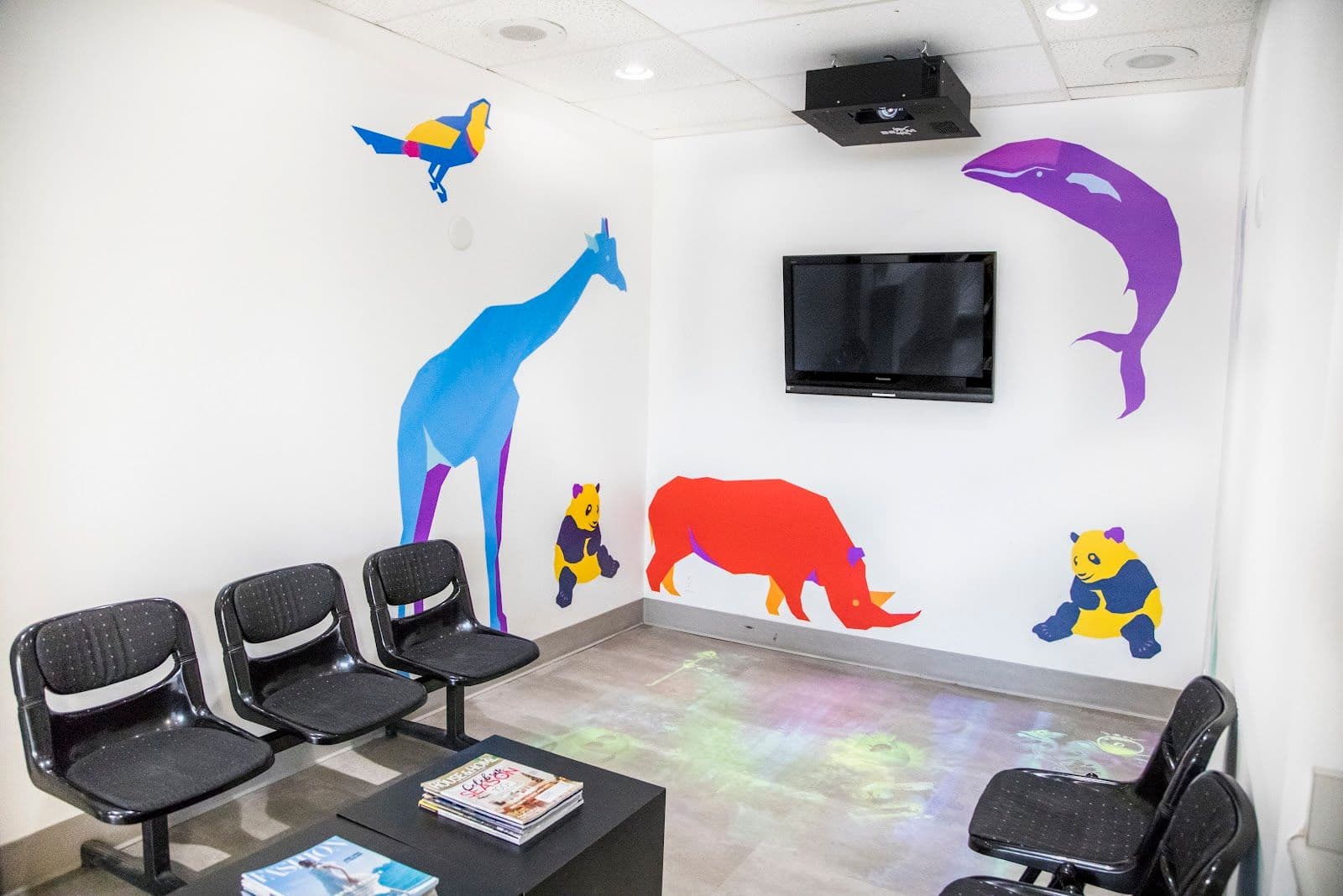 Kids dental clinic team reviewing patient feedback together at the front desk, smiling and looking at a tablet in a bright, welcoming reception area