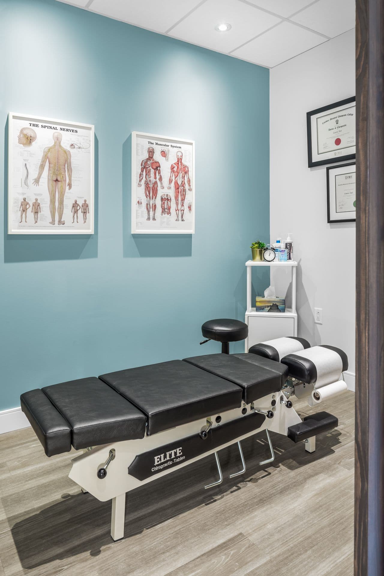 A chiropractic clinic front desk team reviewing patient feedback and Google reviews together on a tablet in a clean, modern treatment area.