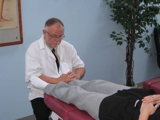 Chiropractic clinic front desk team reviewing patient feedback together on a tablet in the reception area