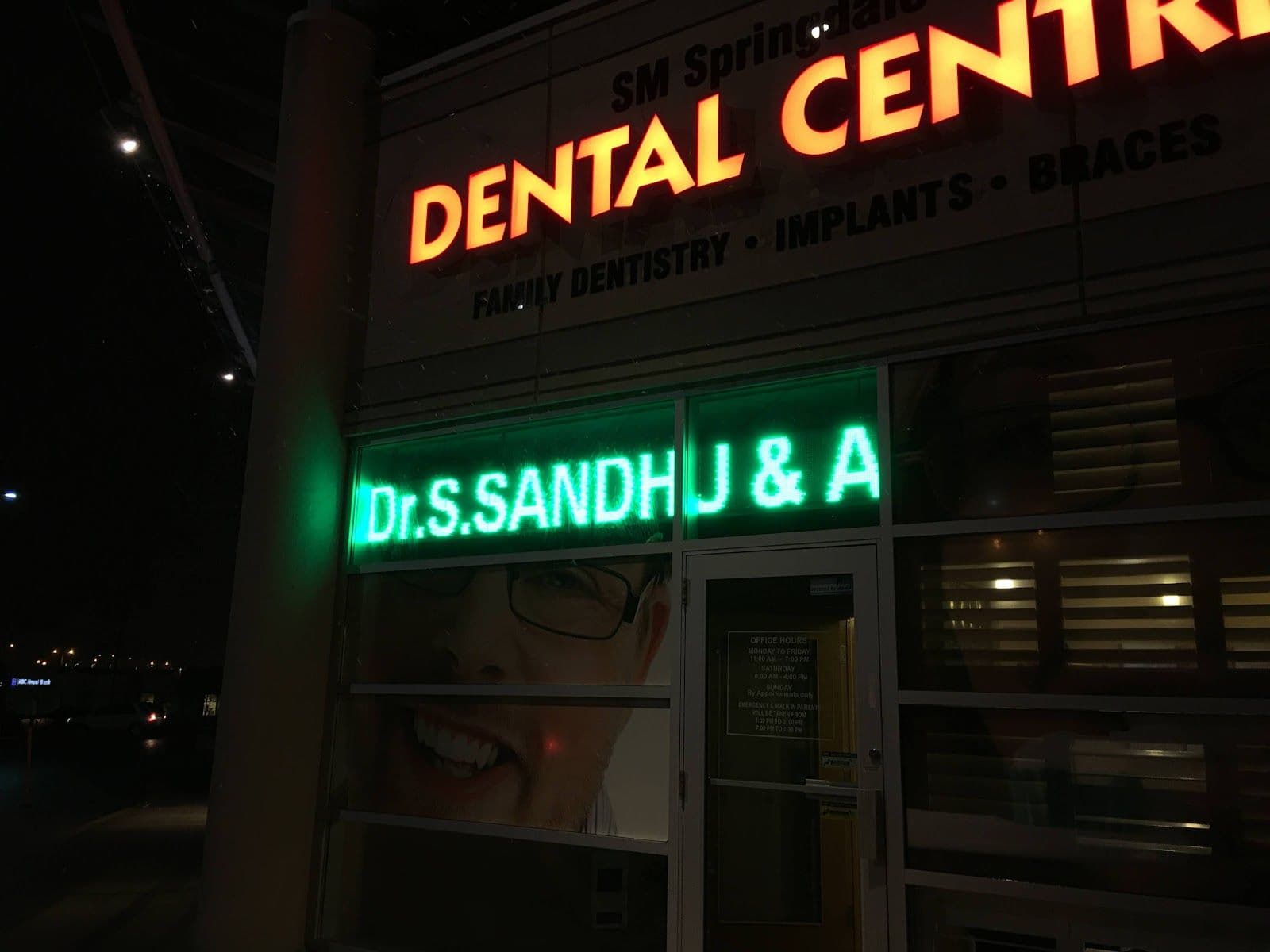 Dental clinic front desk team reviewing patient feedback and Google reviews together on a tablet at the reception area of Sandhu Dentistry