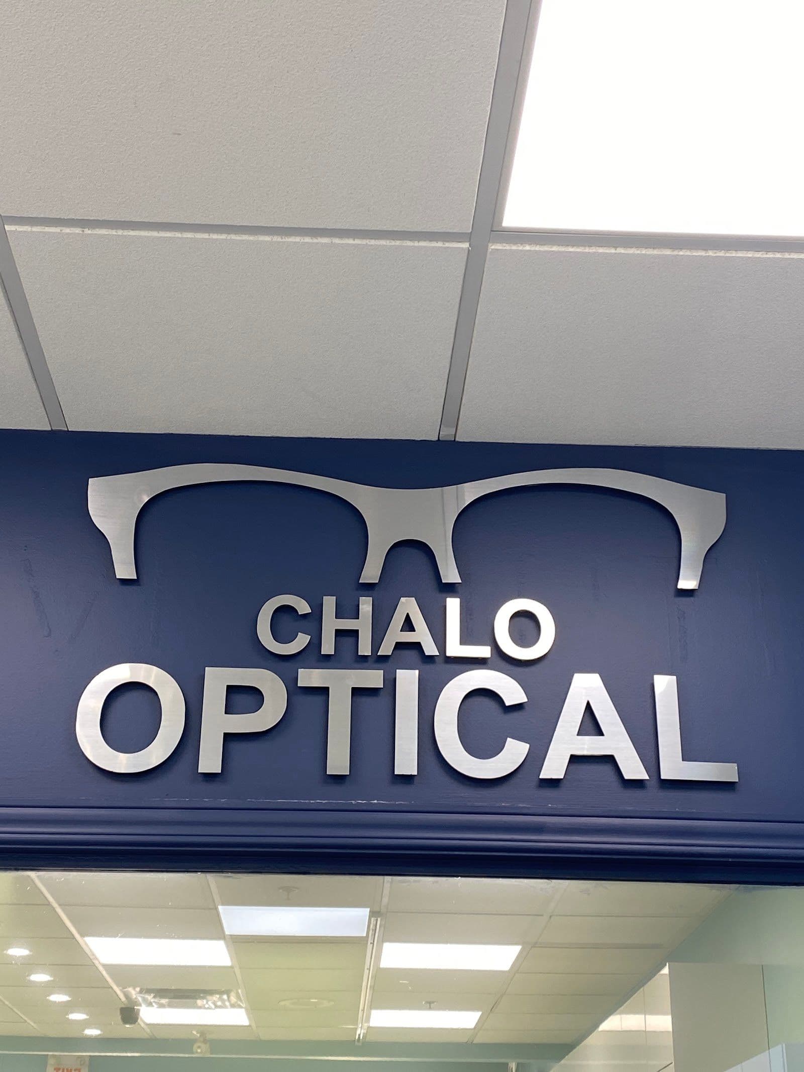 Optometry clinic team reviewing patient feedback and Google reviews together at the front desk of an eye care practice