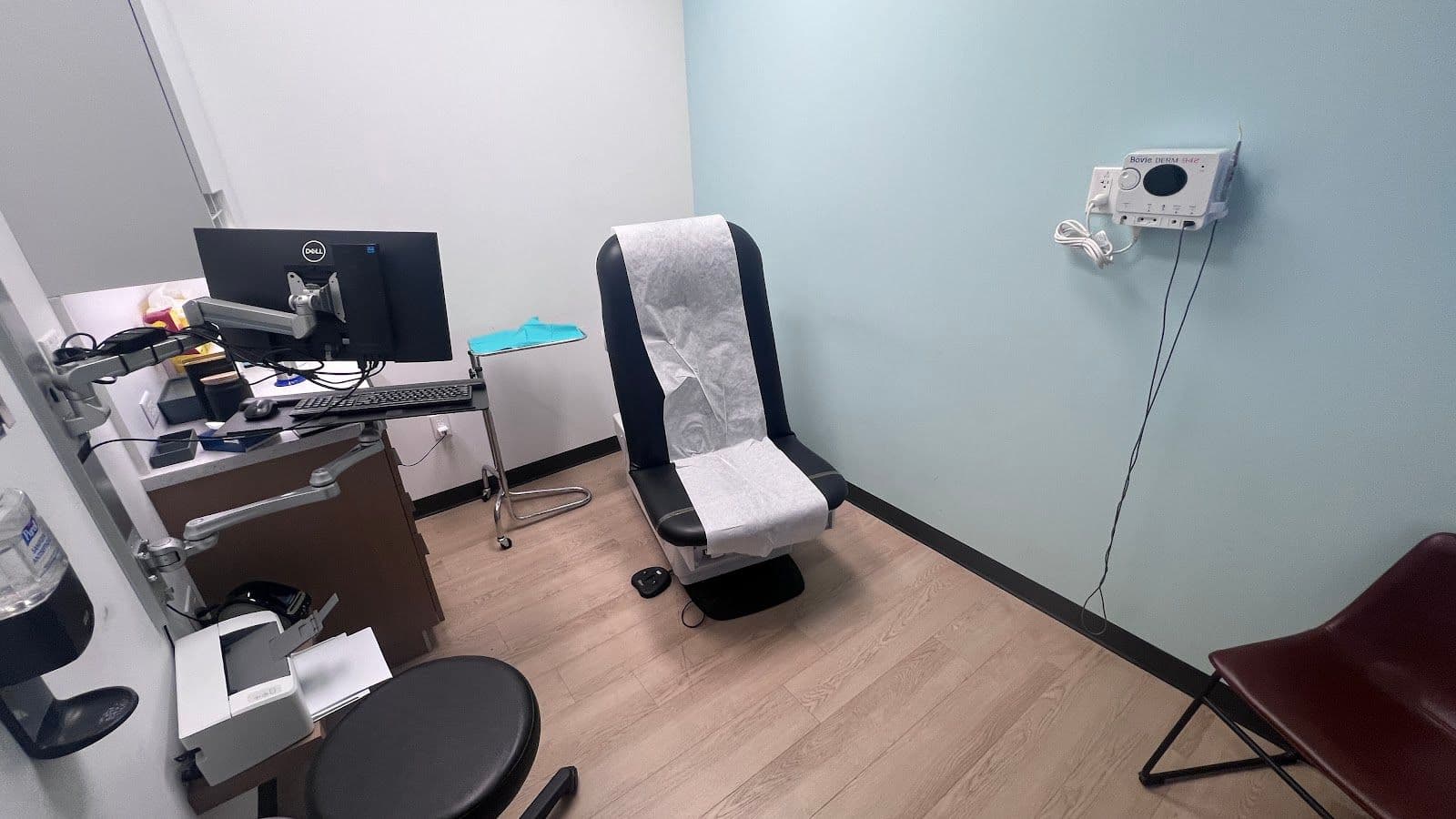Dermatology clinic team reviewing patient feedback together at the front desk, with a tablet showing Google review summaries