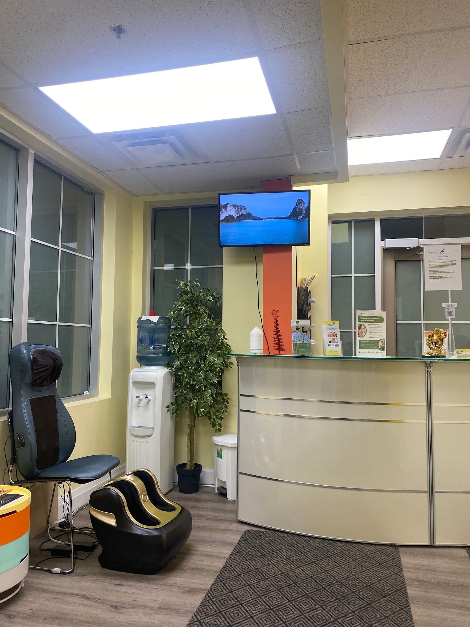 Physiotherapy clinic front desk team reviewing patient feedback together on a tablet in the reception area of Brampton Family Physio