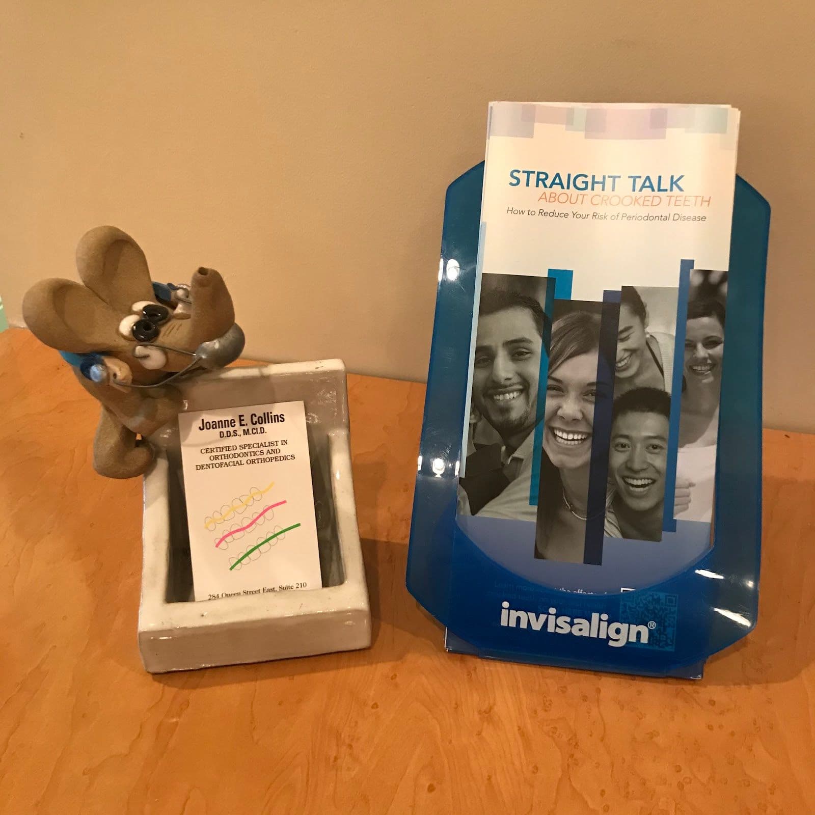 An orthodontic clinic team reviewing patient feedback together at the front desk, with a tablet displaying Google reviews in a bright, welcoming practice setting