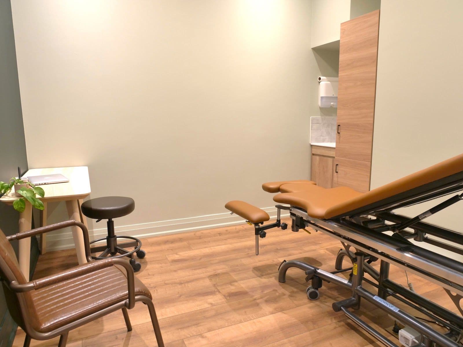 A physiotherapy clinic practitioner and front desk team member reviewing patient feedback together at a clean, welcoming reception area