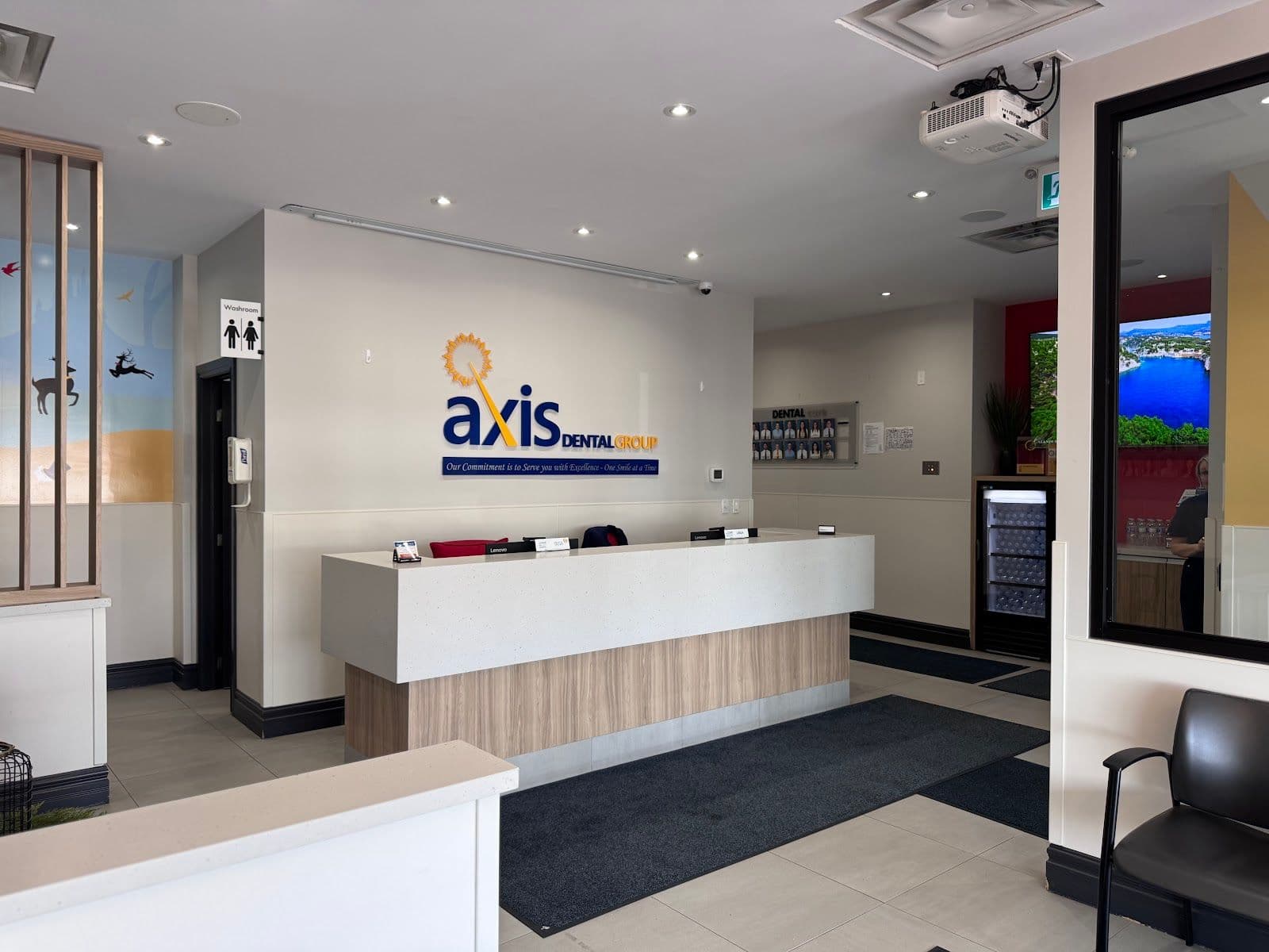 Dental clinic front desk team reviewing patient feedback on a tablet together in the reception area at AXIS Dental