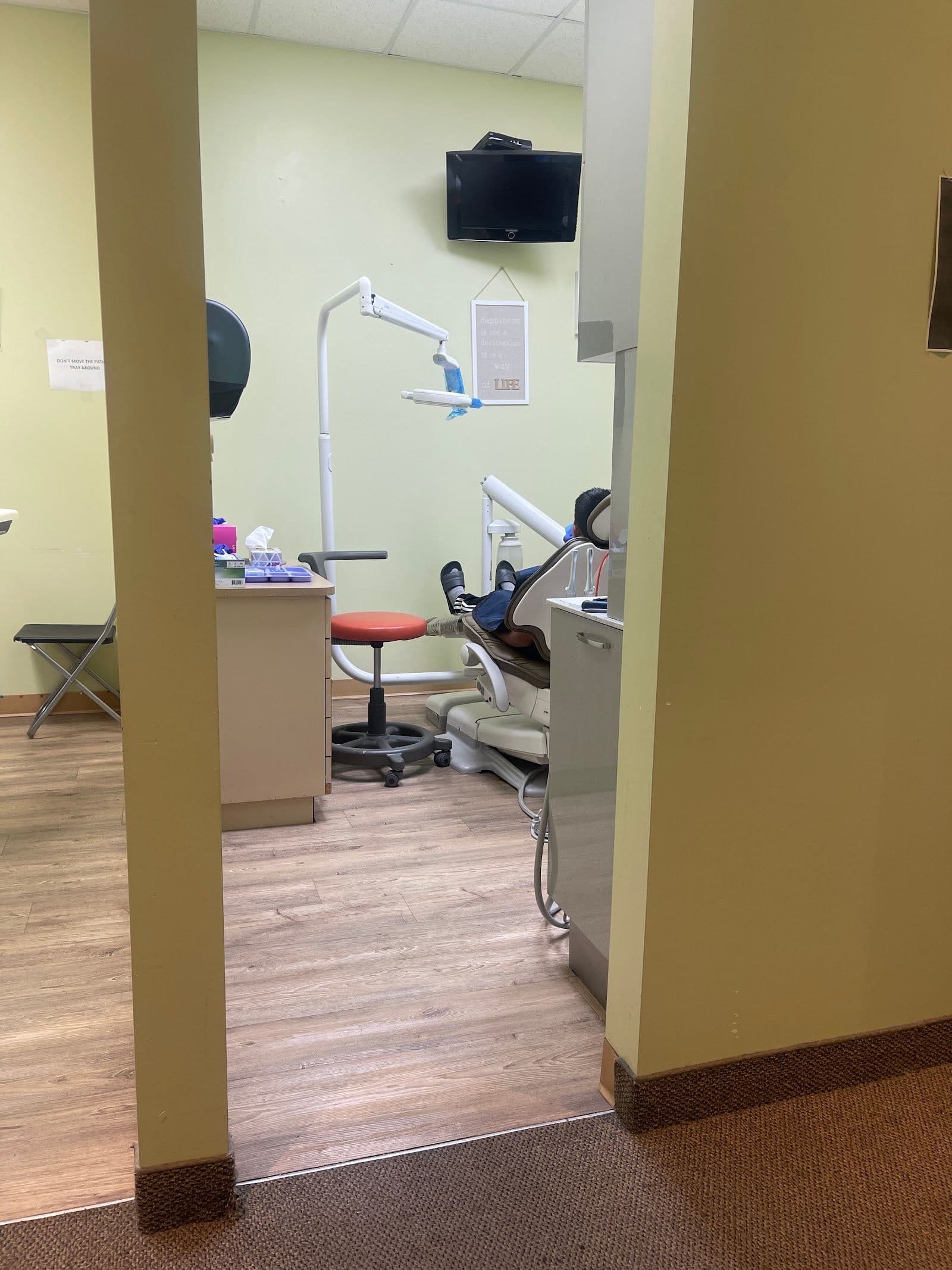 Dental clinic front desk team reviewing patient feedback on a tablet in a clean, modern reception area at Queen Chinguacousy Dentistry