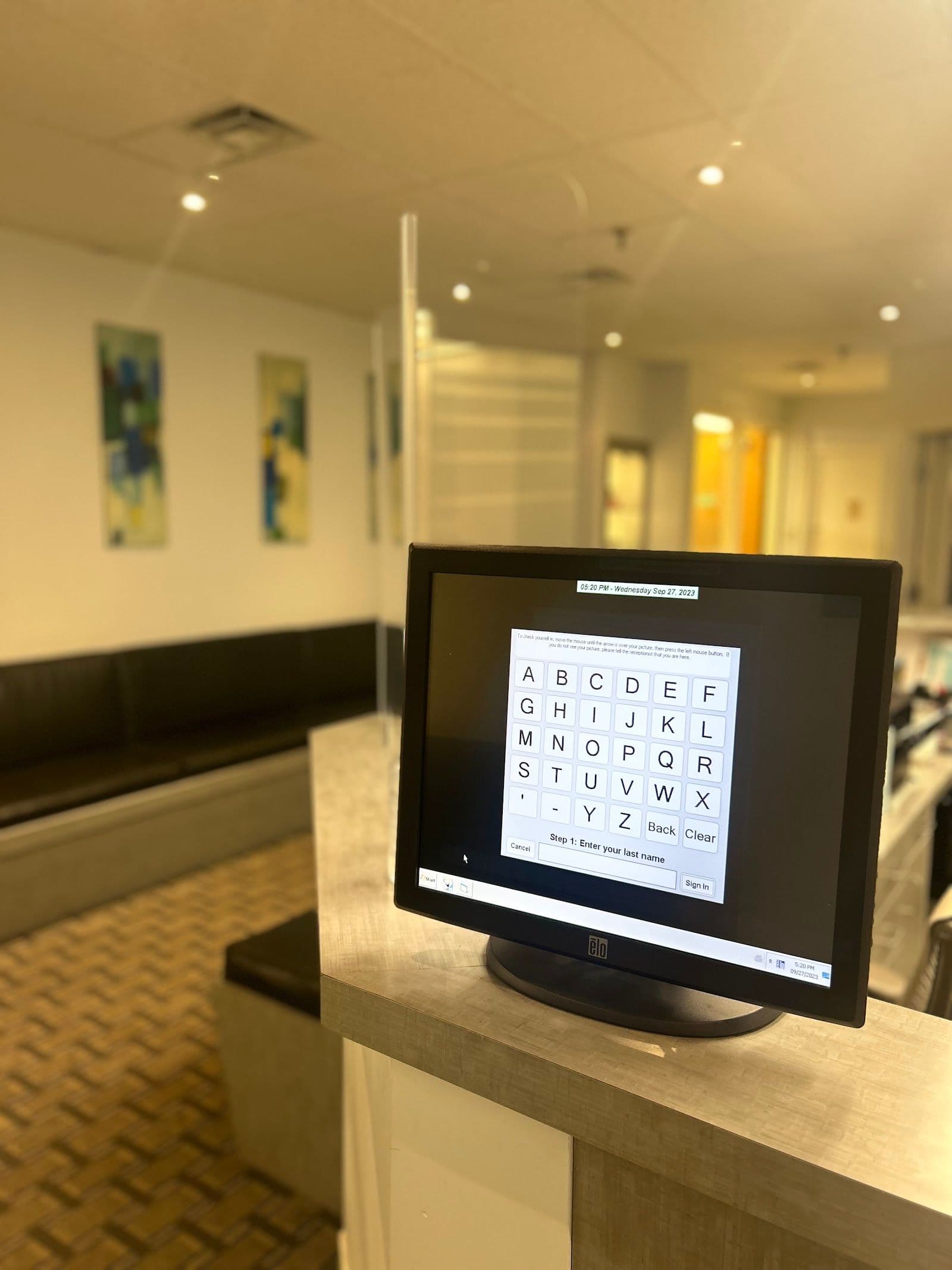 Orthodontic clinic front desk team reviewing patient feedback together on a tablet in a bright modern reception area