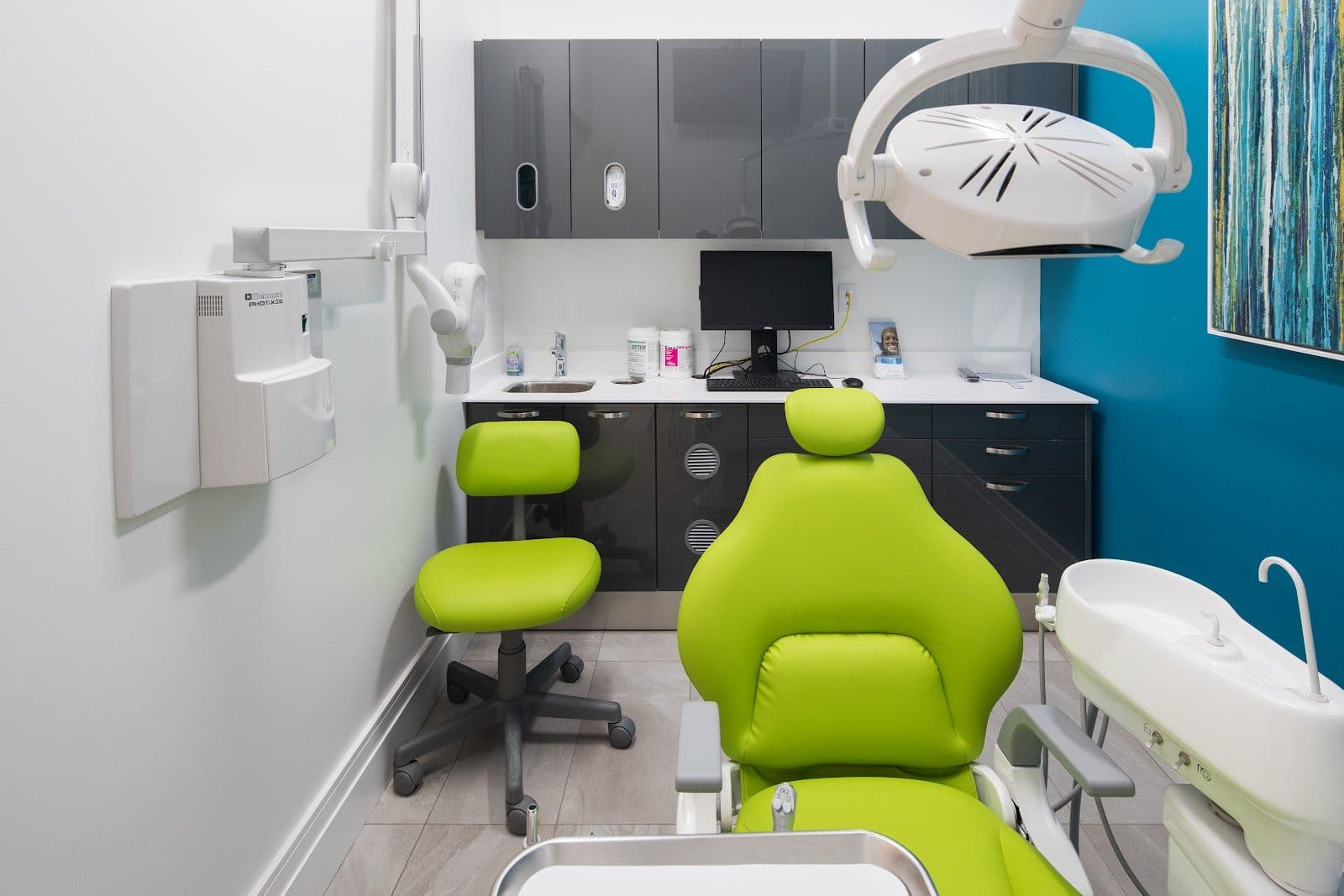 A dental clinic front desk team reviewing patient feedback together on a tablet in a modern, well-lit reception area