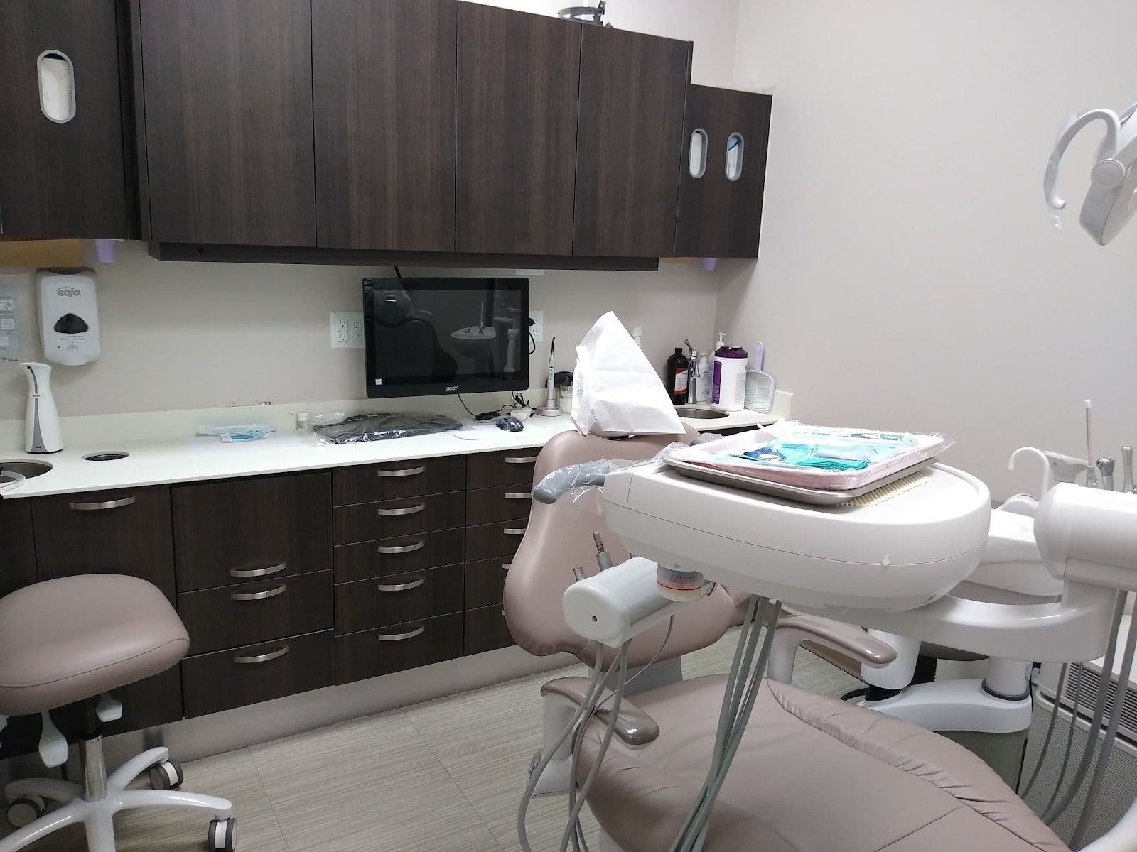 A dental clinic front desk team reviewing patient feedback on a tablet together in a bright, welcoming reception area
