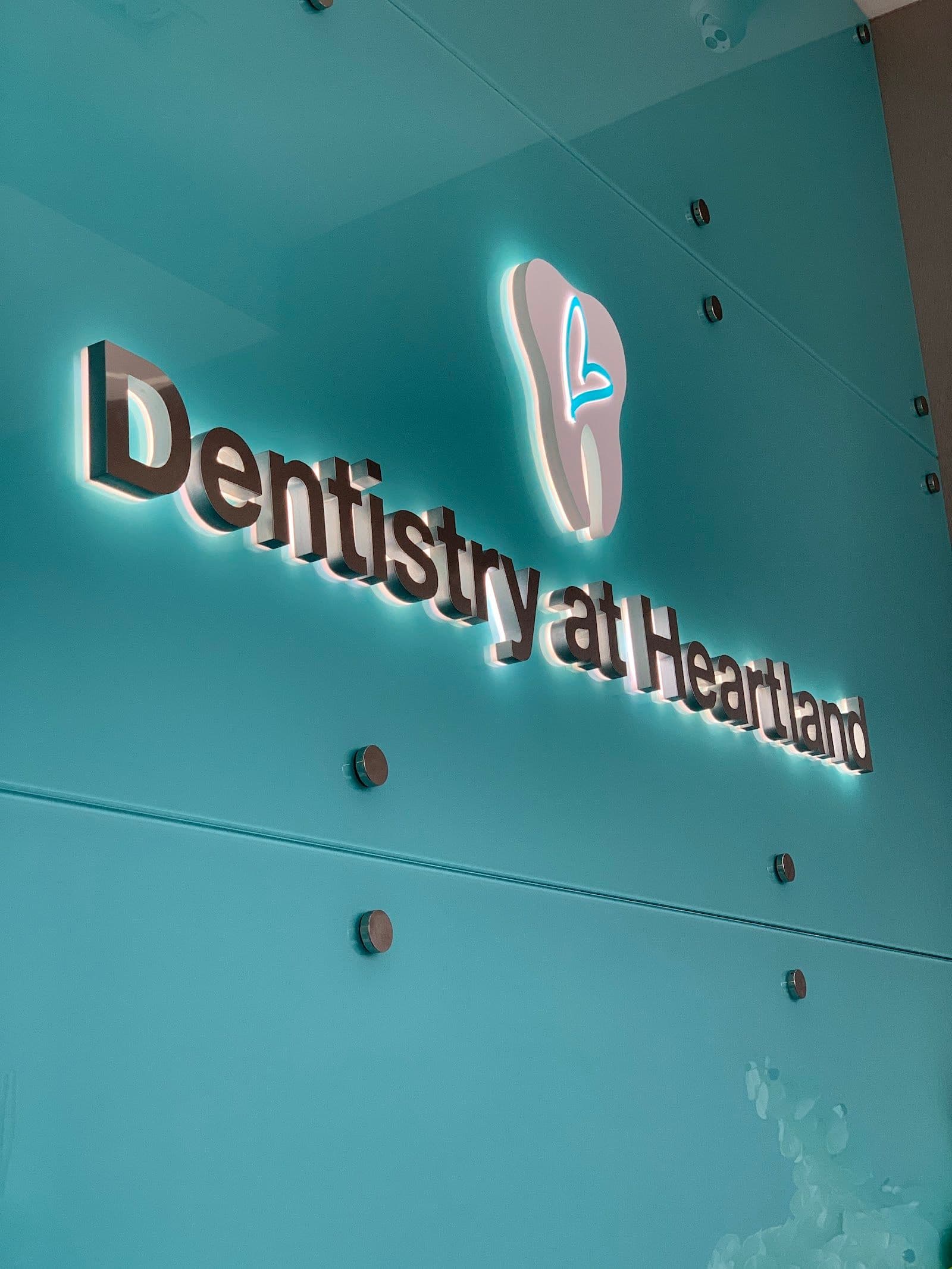 A dental clinic front desk team reviewing patient feedback and Google review summaries together on a tablet at the reception area