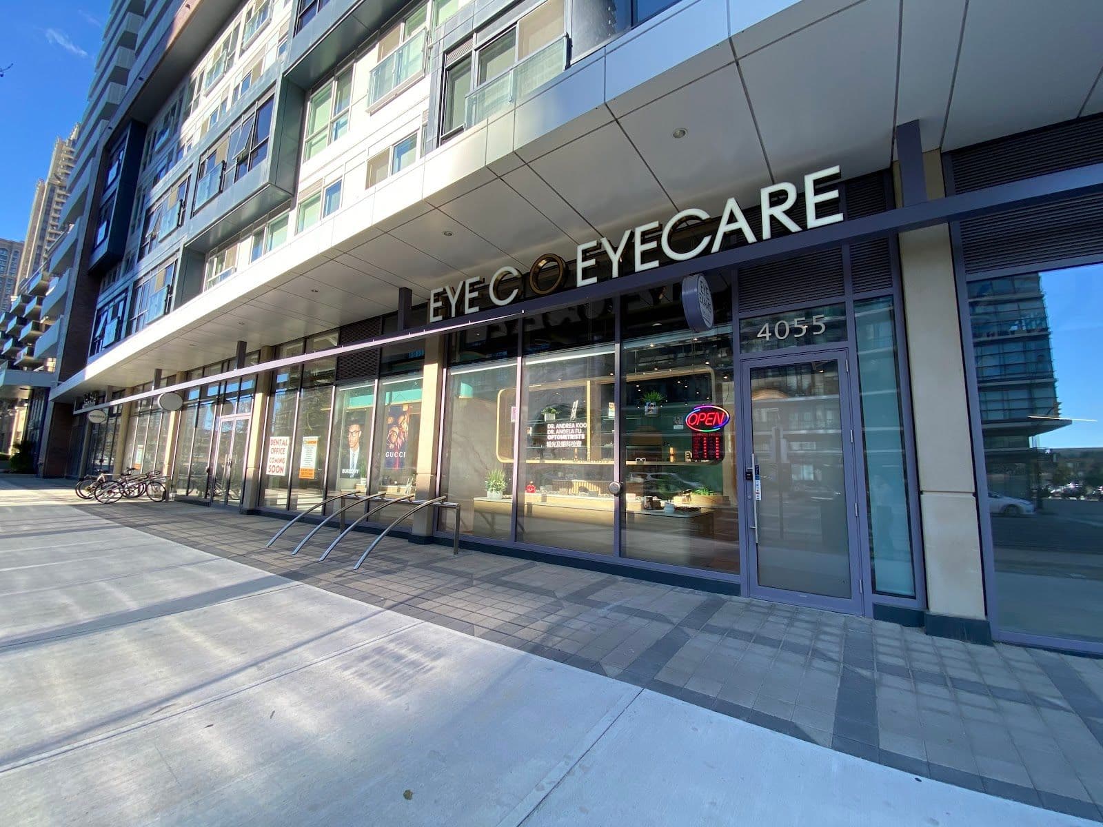 Optometry clinic team member reviewing patient feedback and Google review summaries on a tablet at the front desk of an eyewear practice