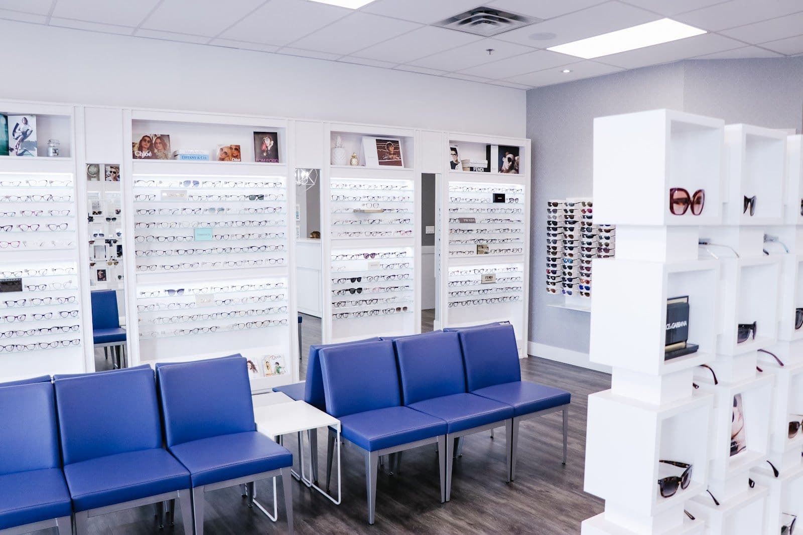 Optometry clinic front desk team reviewing patient feedback together on a tablet at the reception area of an eye care practice