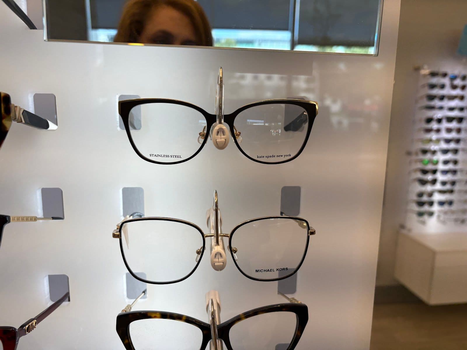 Arc Eyecare optometry team reviewing patient feedback together at the front desk, with a computer screen displaying Google review summaries