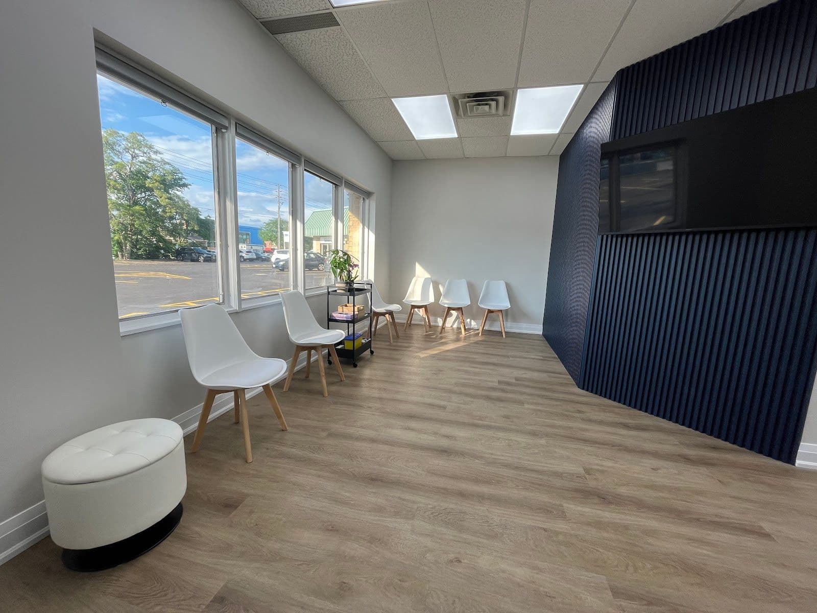 A clinic team member and practitioner reviewing patient feedback together at the front desk of a clean, modern rehabilitation and wellness clinic