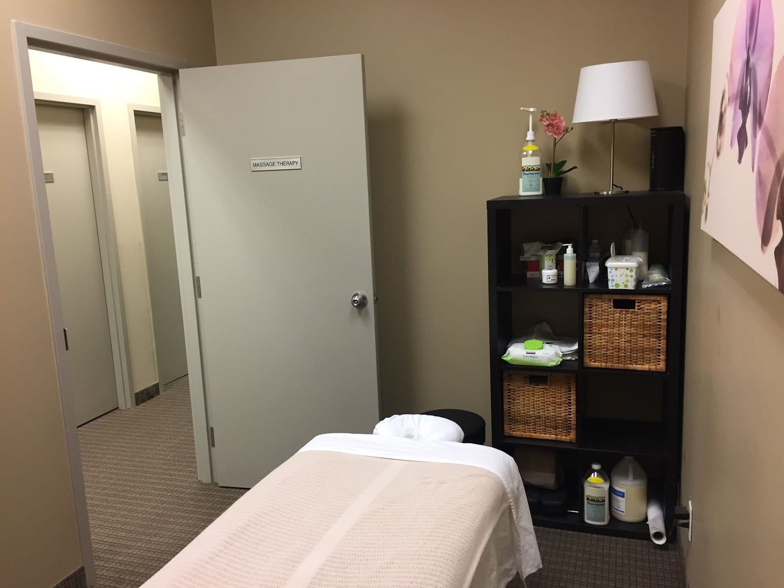 Chiropractic clinic front desk team reviewing patient feedback together on a tablet in a bright, welcoming treatment area