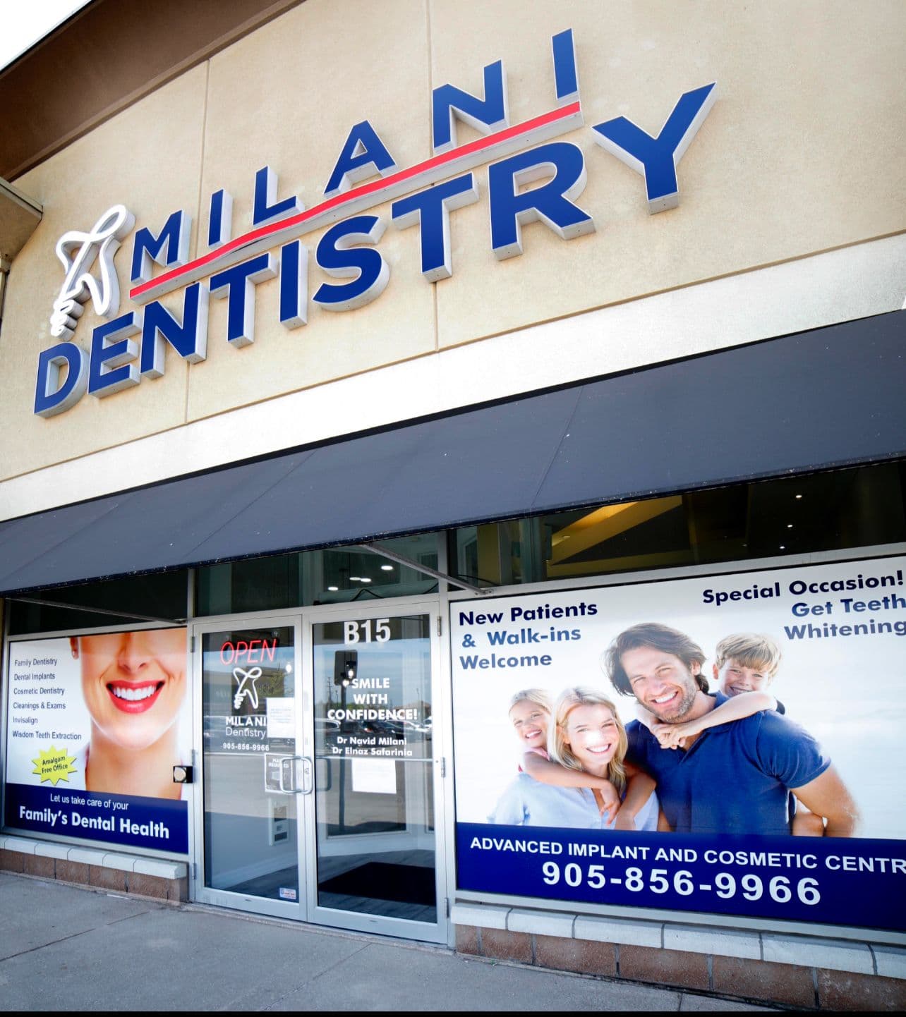 A dental clinic team member and front desk lead reviewing patient feedback together on a tablet at the reception desk of Milani Dentistry
