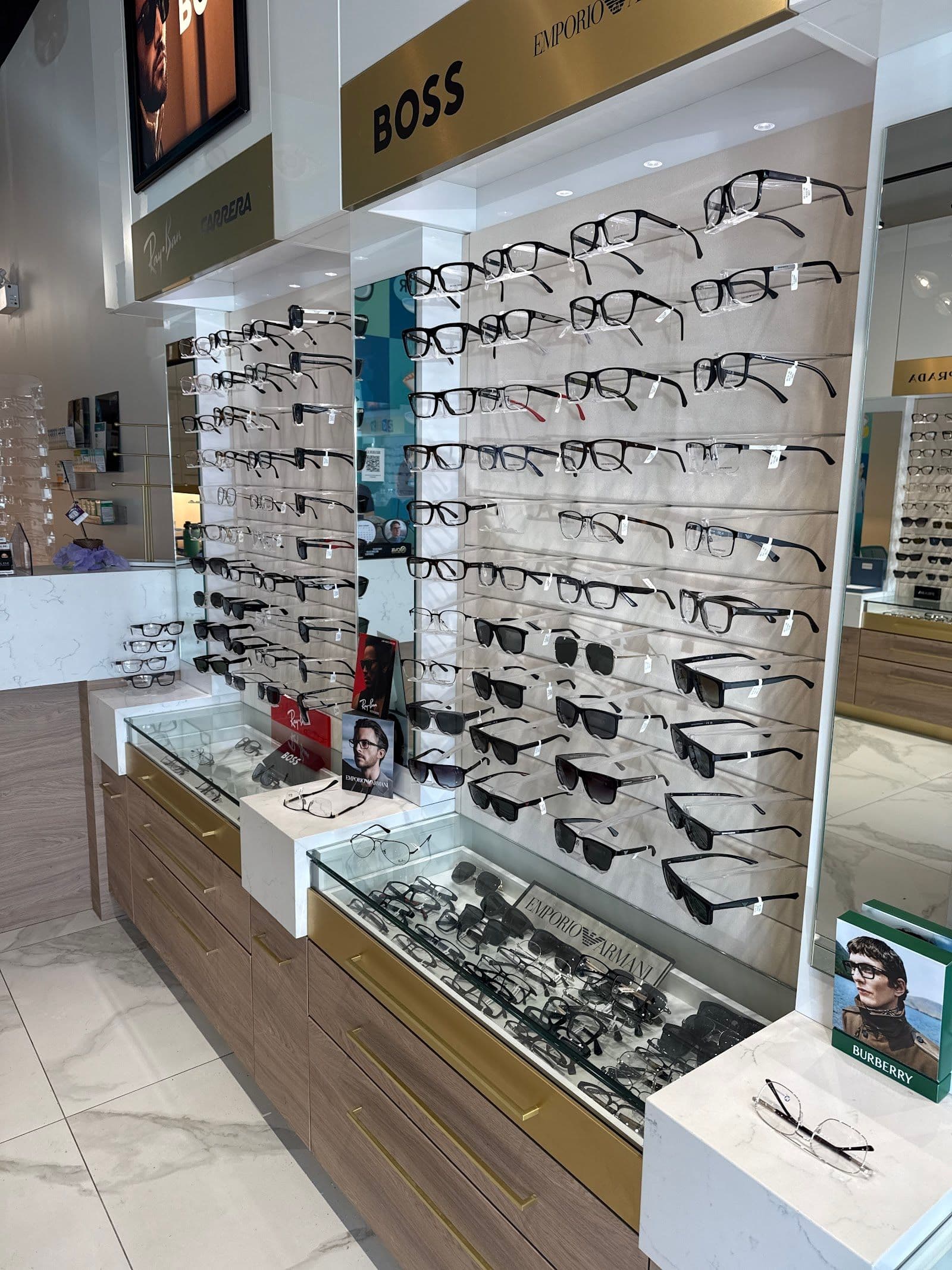 Optometry clinic team reviewing patient feedback and Google reviews together at the front desk of an optical practice