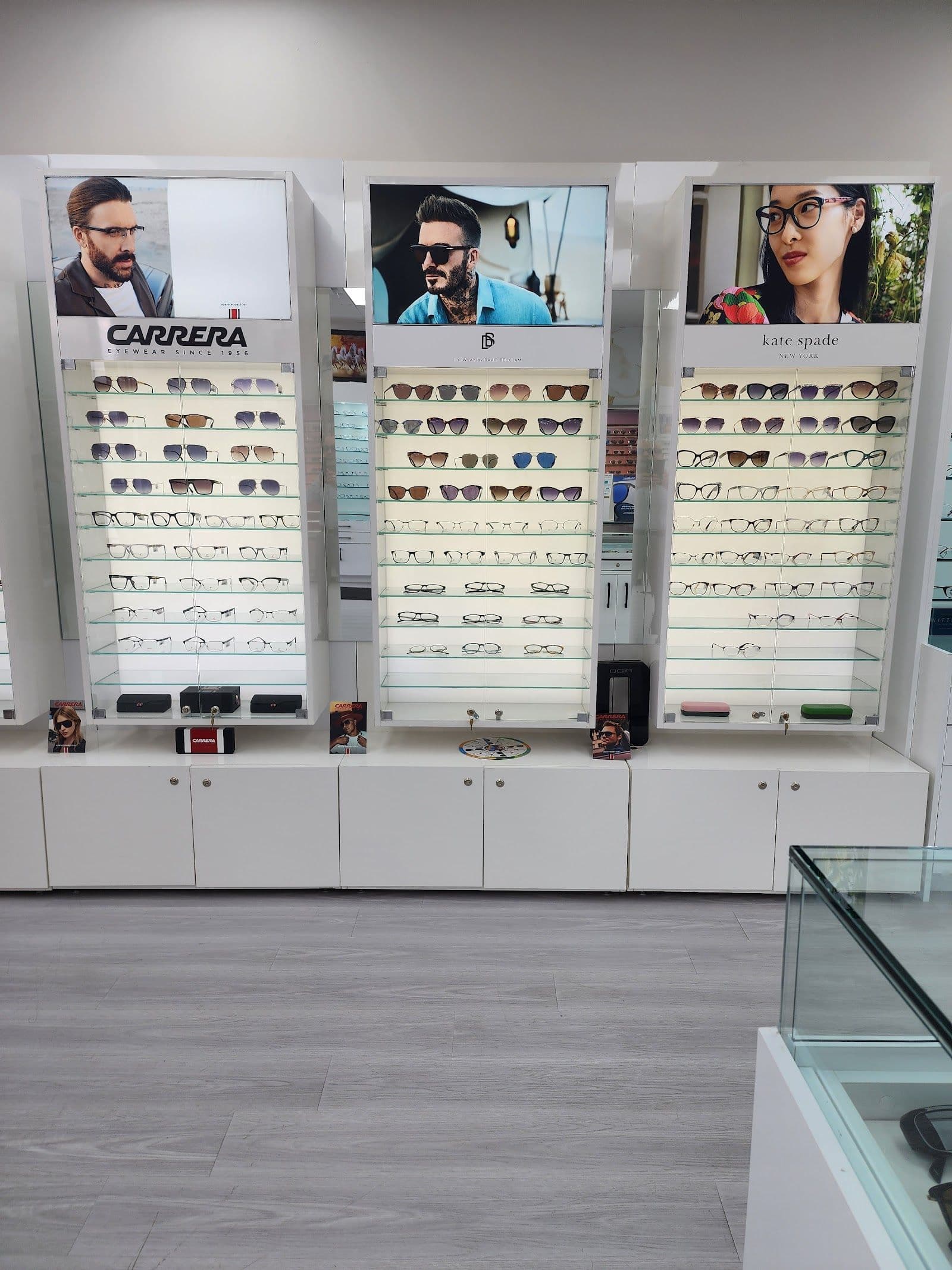 Optical clinic staff member reviewing patient feedback and Google reviews on a tablet at the front desk of an eyewear centre