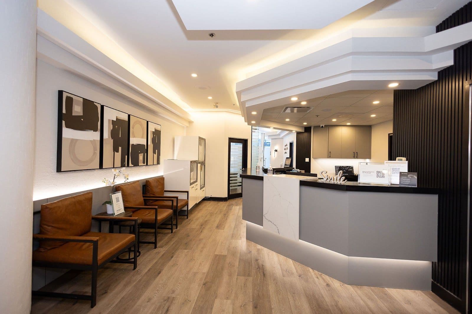 Dental clinic front desk team reviewing patient feedback together on a tablet in a clean, modern reception area