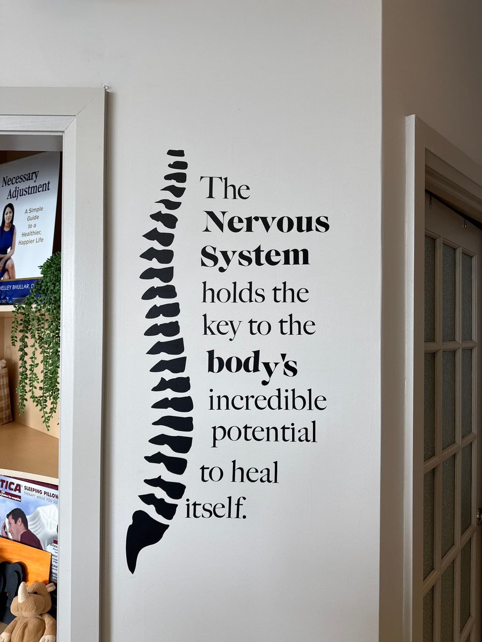 Chiropractic clinic front desk team reviewing patient feedback together on a tablet in a bright, welcoming reception area
