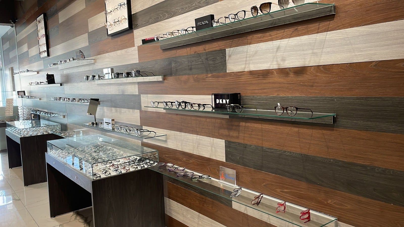 Optometry clinic front desk team reviewing patient feedback together on a tablet in a clean, modern reception area