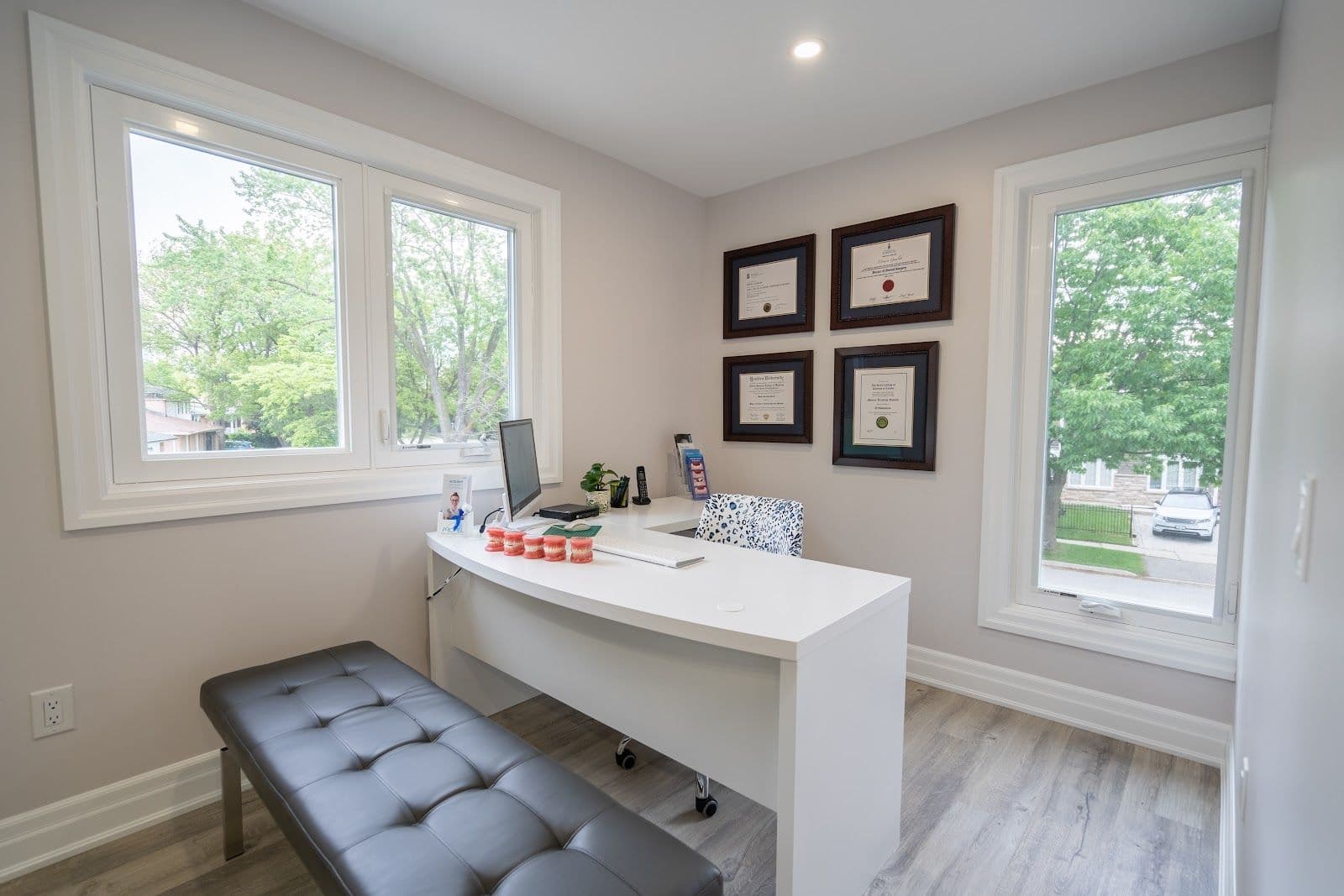 Orthodontic clinic front desk team reviewing patient feedback on a tablet in a bright, clean treatment area