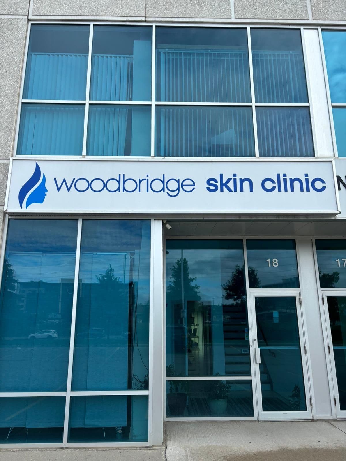 A clinic team member and practitioner reviewing patient feedback together at the front desk of a modern skin clinic