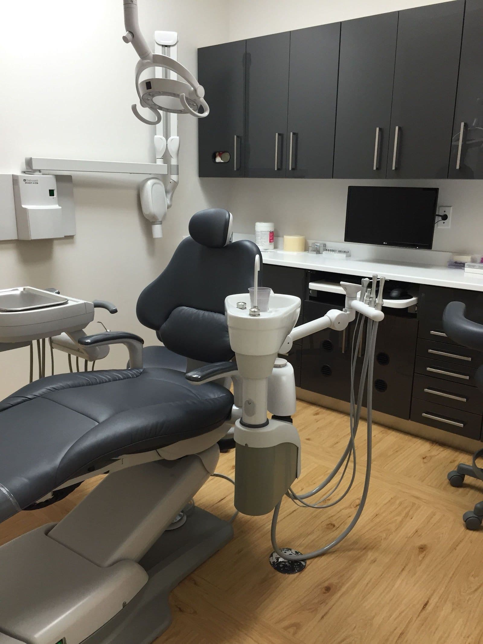 Dental clinic front desk team reviewing patient feedback together on a tablet in a bright, modern reception area