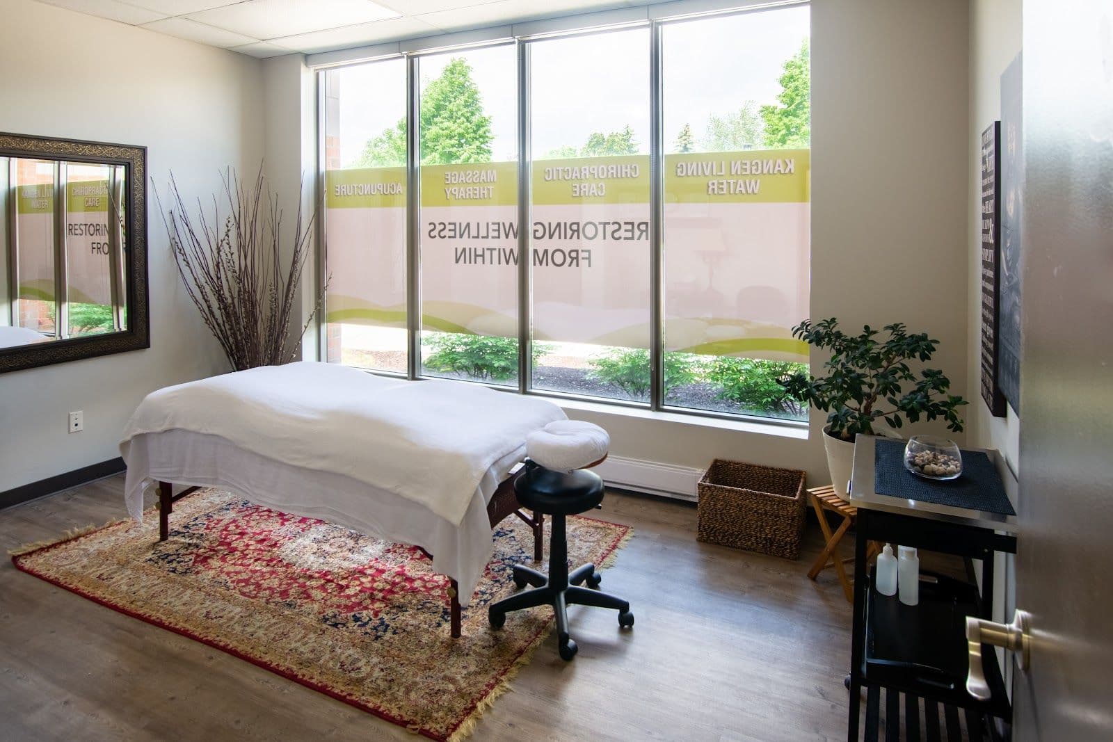 Chiropractic clinic front desk staff reviewing patient feedback together on a tablet in a clean, welcoming reception area