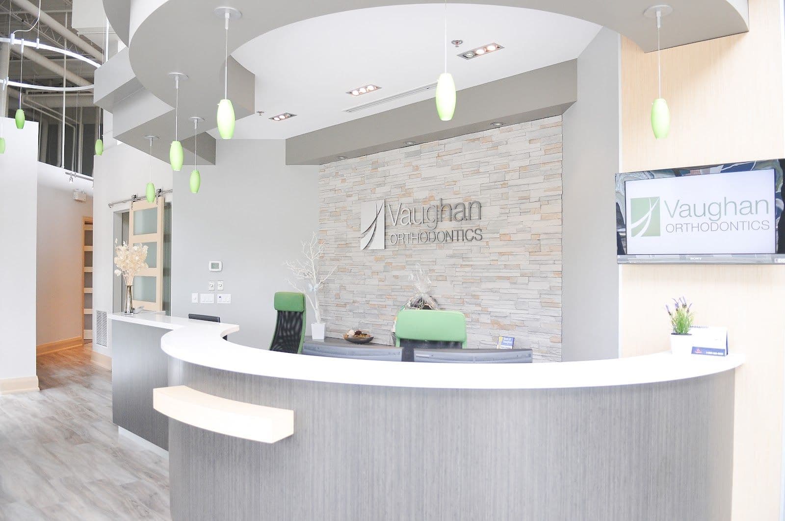 Orthodontic clinic team reviewing patient feedback and Google reviews together at the front desk