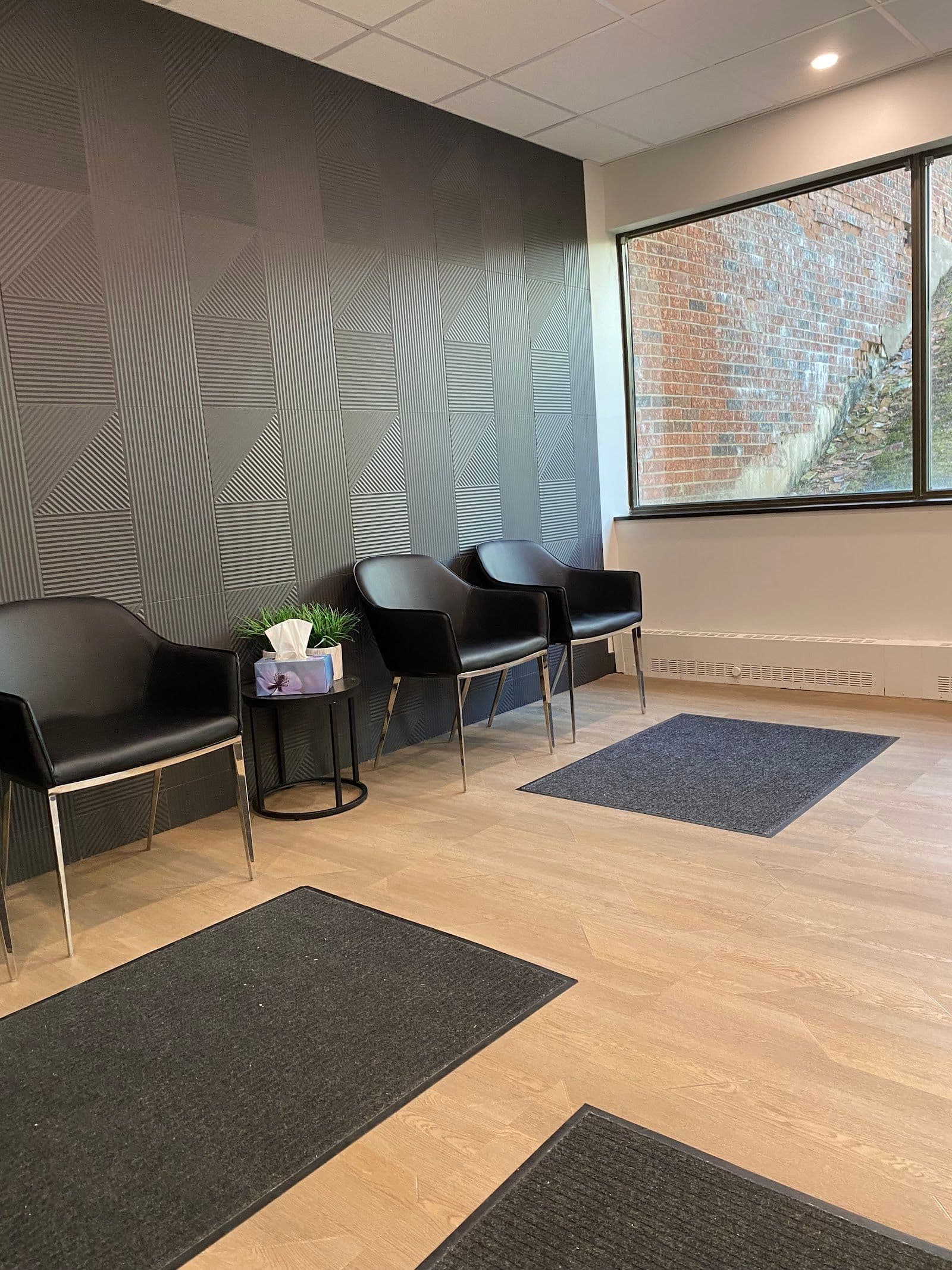 Dental clinic front desk team reviewing patient feedback together on a tablet in a bright, modern reception area