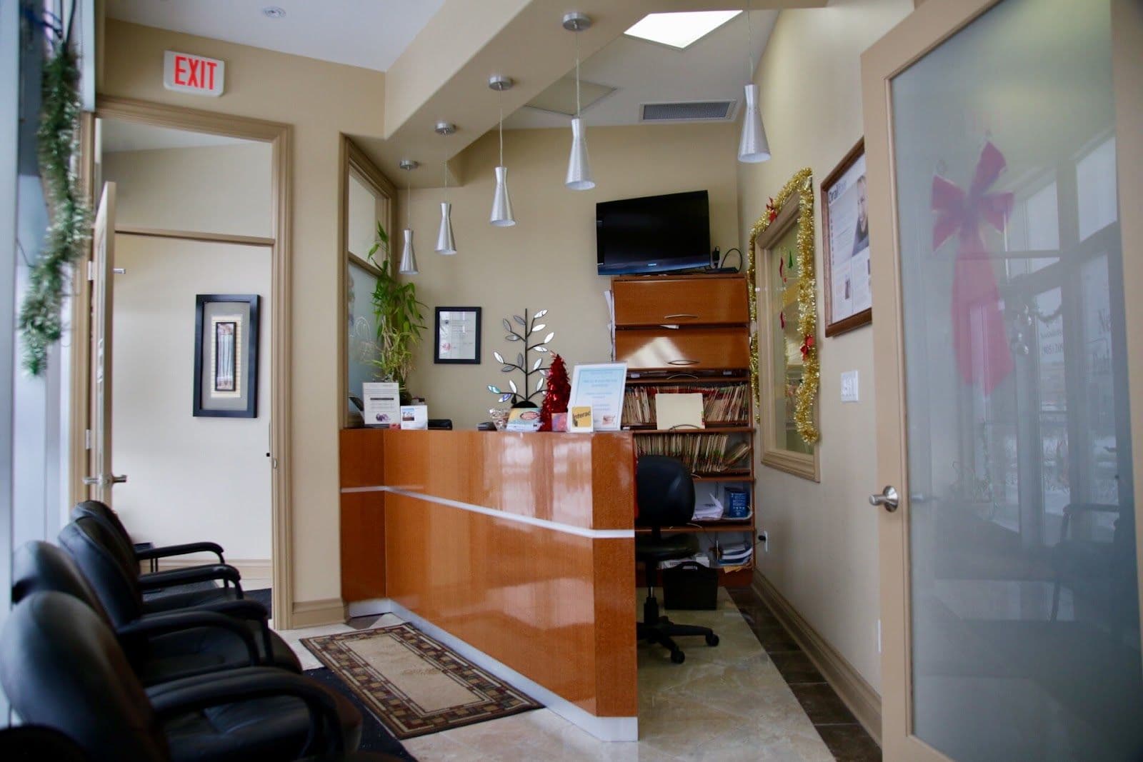 Dental clinic front desk team reviewing patient feedback together on a tablet in a clean, modern reception area