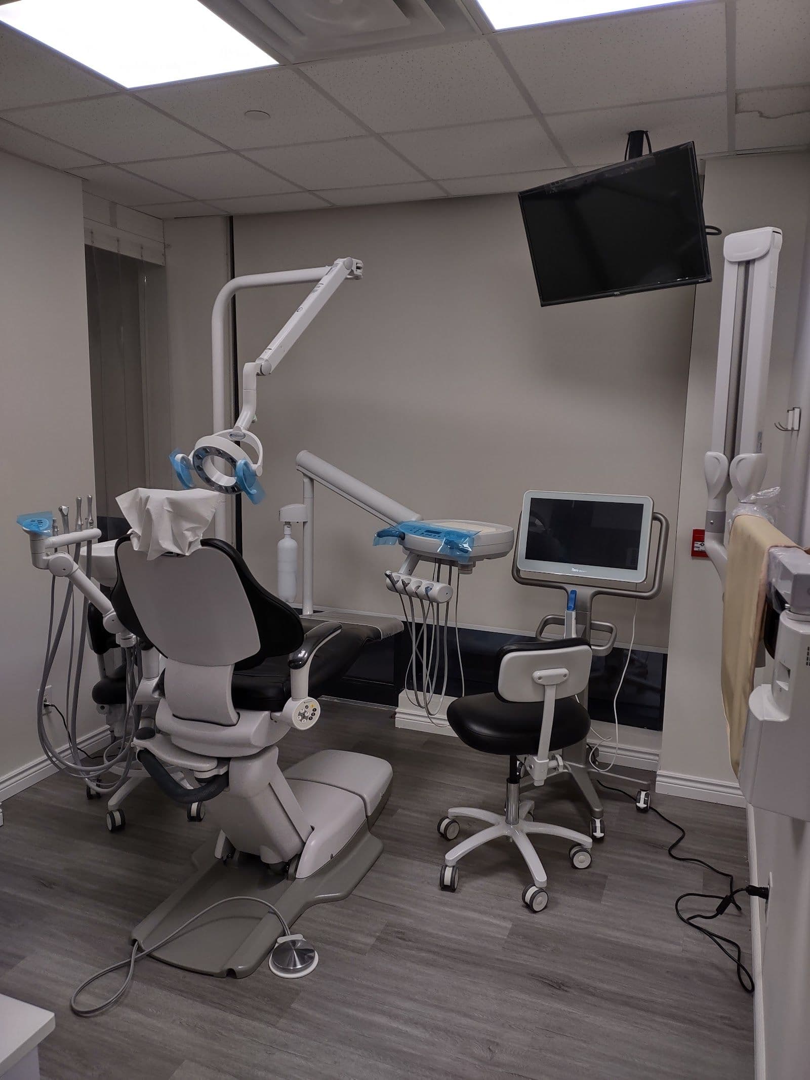 Dental clinic front desk team and dentist reviewing patient feedback together on a tablet in a clean, modern treatment area