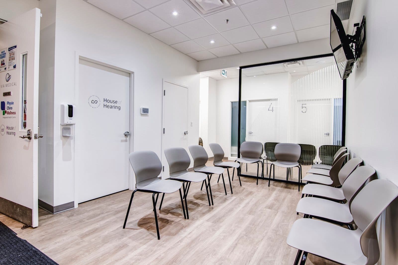 A clinic coordinator and physiotherapist reviewing patient feedback together at the front desk of a physio and chiropractic clinic