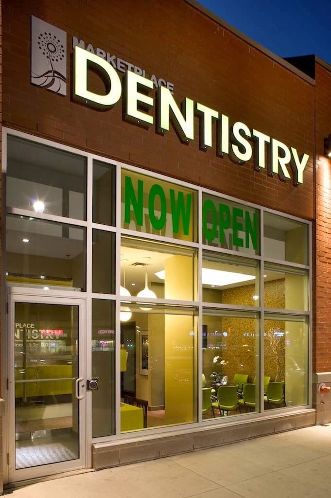 Dental clinic front desk team member reviewing patient feedback on a tablet at the reception area of Marketplace Dentistry