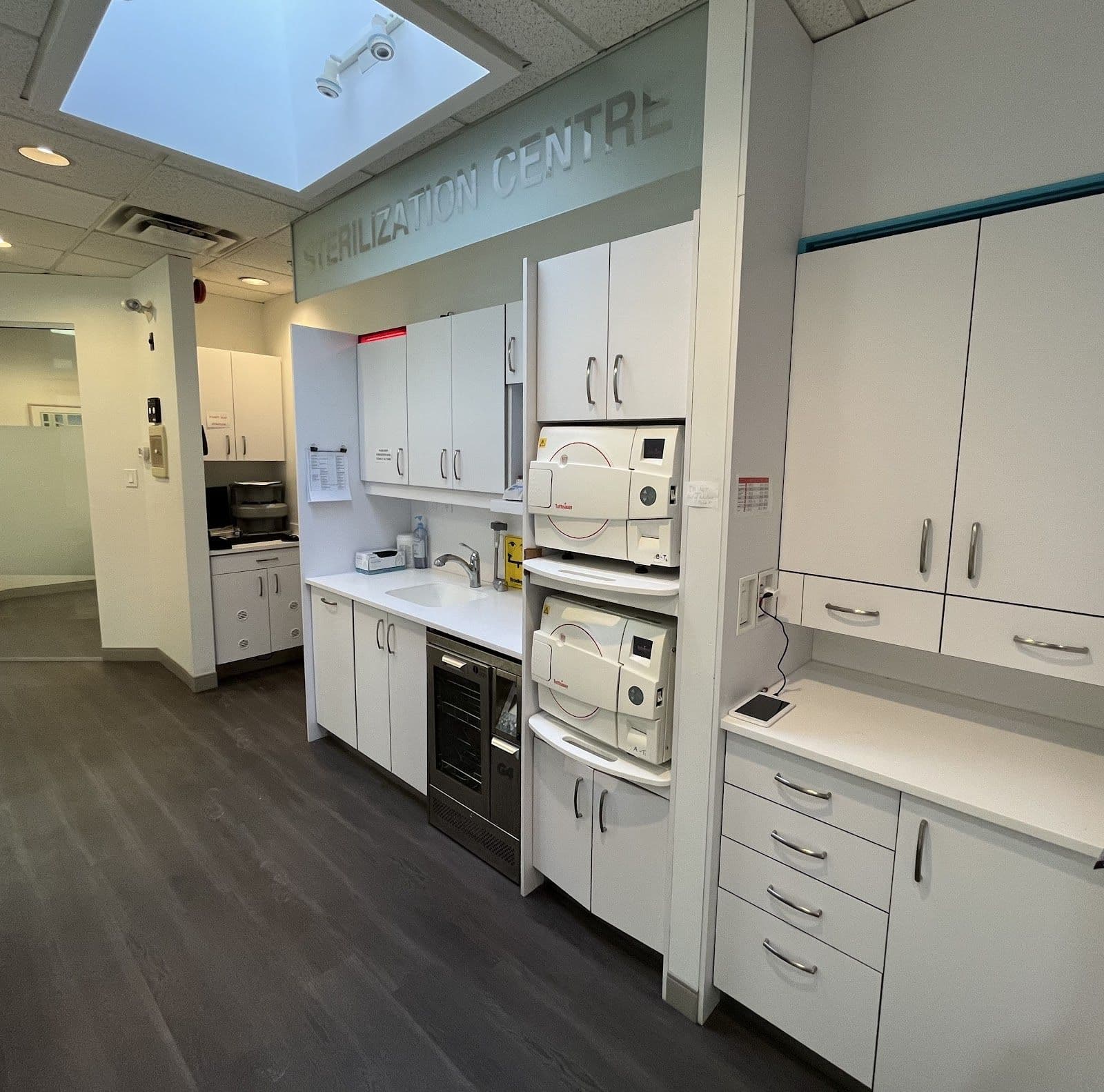 Dental clinic front desk team reviewing patient feedback together on a tablet inside a bright, clean treatment area