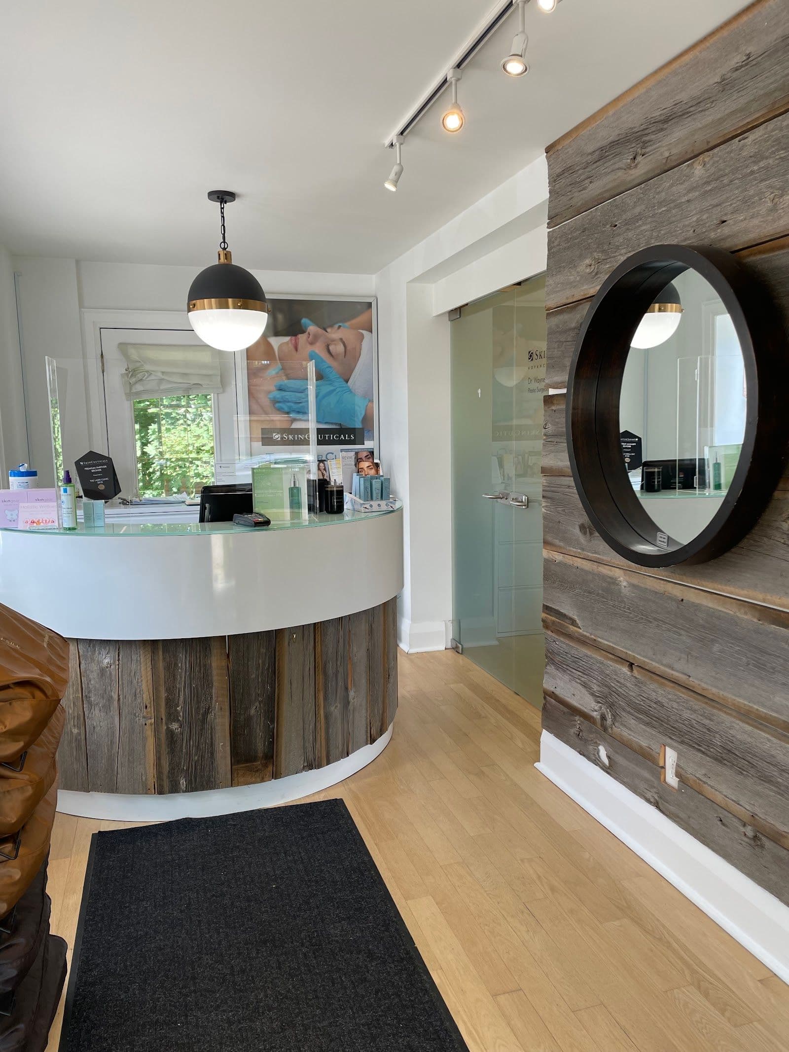 Aesthetic clinic practitioner and front desk team reviewing patient feedback together at a clean, modern treatment reception area