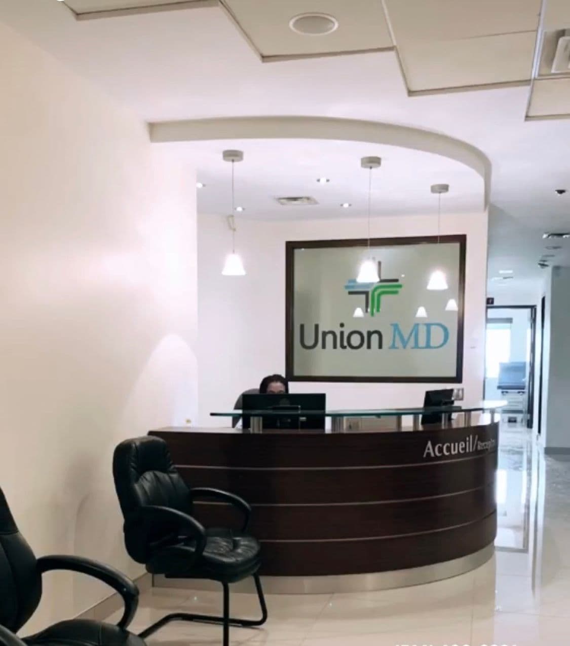 A dermatology clinic front desk team reviewing patient feedback together on a tablet in a clean, modern treatment area