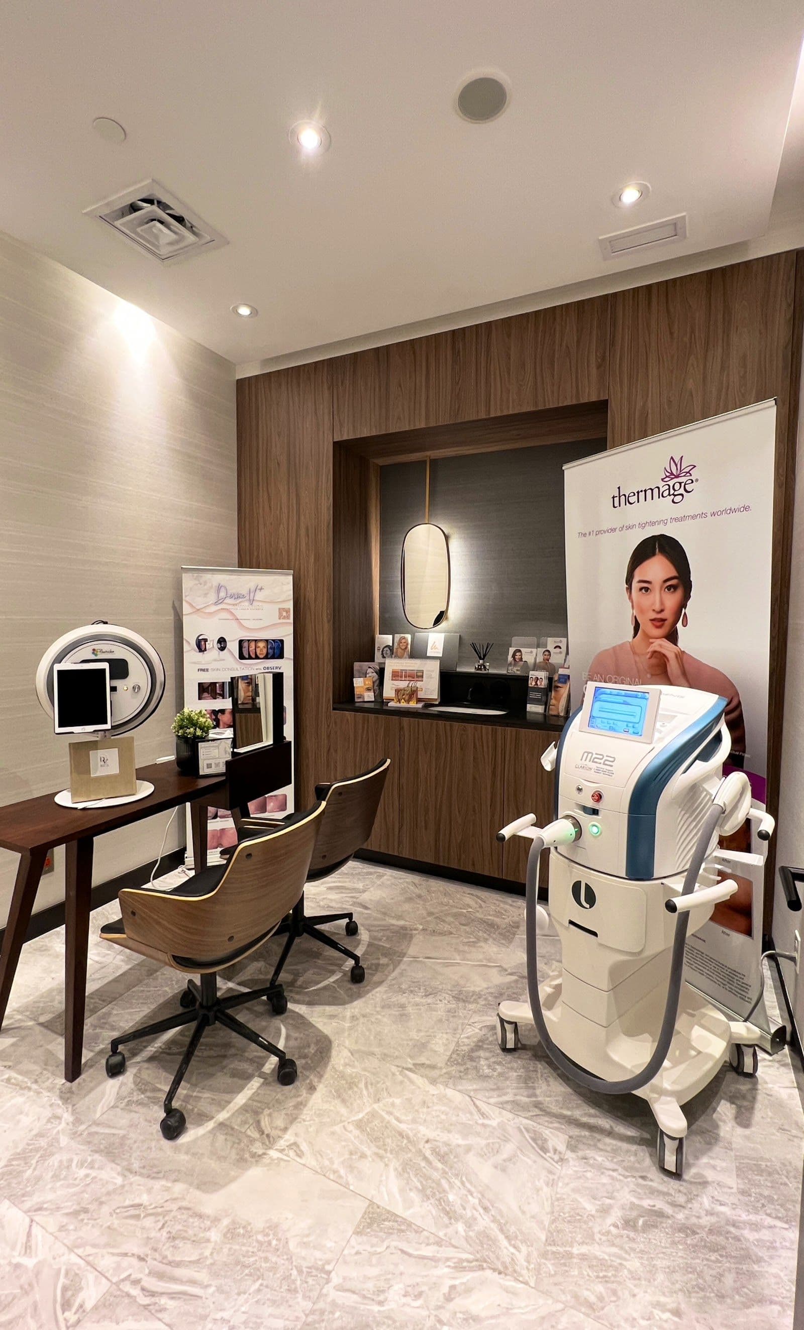 Cosmetic clinic team member reviewing patient feedback on a tablet at the front desk of a modern treatment clinic